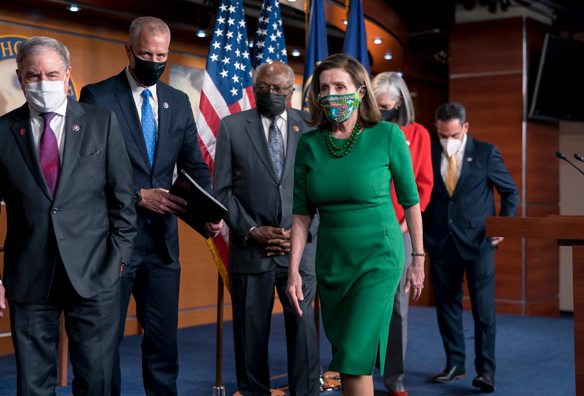 Representanthusets demokratiska talman Nancy Pelosi, i grönt, omgiven av partikamrater kort före omröstningen om hjälppaketet.