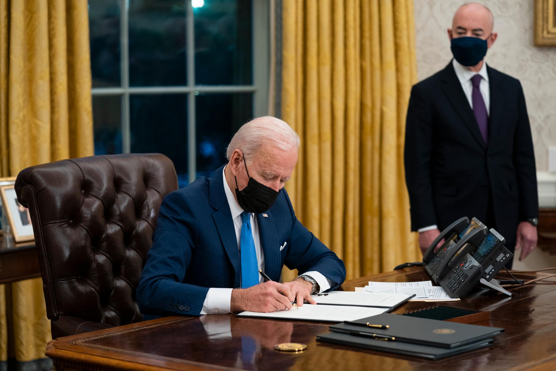 Joe Biden, i Vita huset den 2 februari, skriver under en presidentorder om att återförena flyktingfamiljer som splittrats när de kommit till USA.