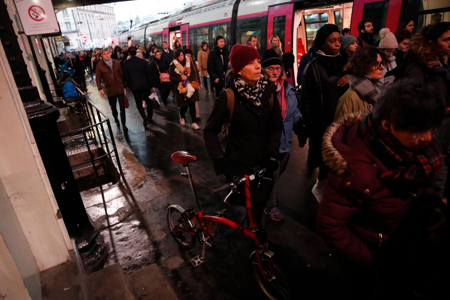 Pendlare som drabbats av strejken går på ett tåg på stationen Saint-Lazare i Paris.