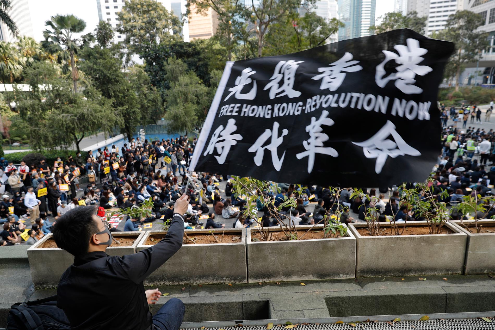 En aktivist med en flagga under den första lunchprotesten i Hongkong av fem planerade den här veckan.