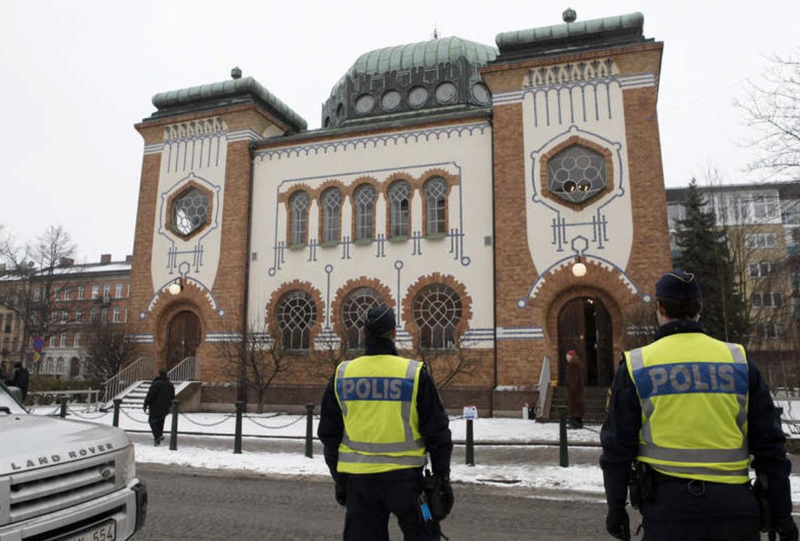 Polisen bevakar judiska församlingens minnesstund i synagogan i Malmö i samband med Förintelsens minnesdag 2013.