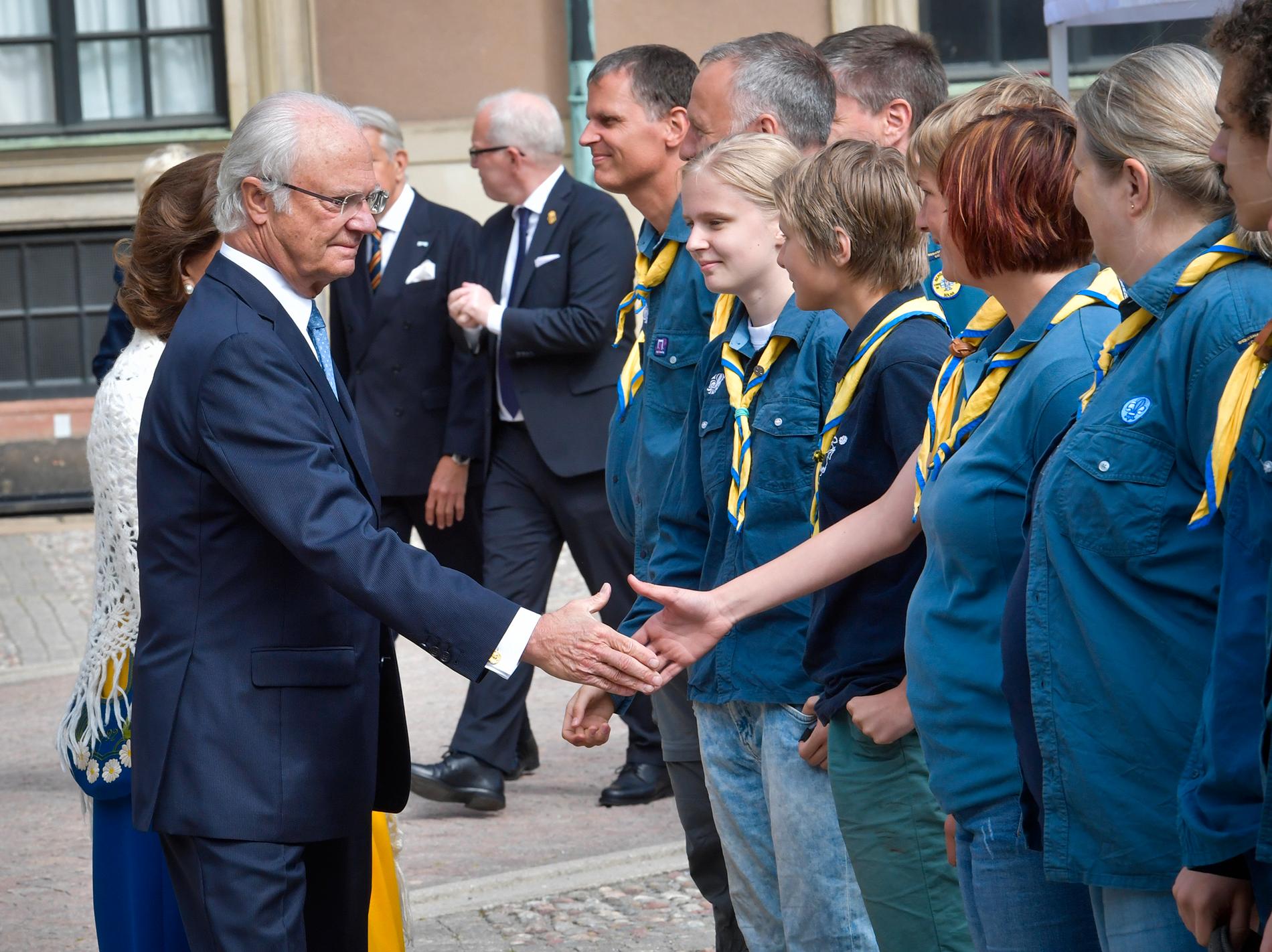 Kung Carl Gustaf och drottning Silvia hälsar på medlemmar ur Bergshamra scoutkår, under nationaldagsfirandet på Stockholms slott. 