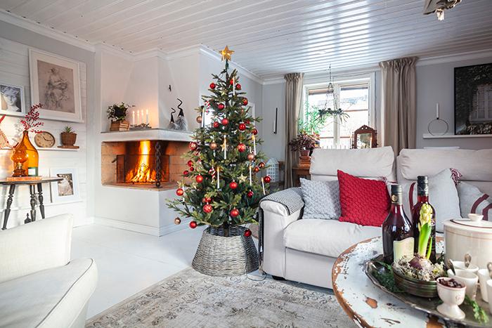 Vardagsrummet på nedervåningen är stort. Den öppna spisen skapar en härlig julstämning. Eva har valt ljusa färger, eftersom det är lättare att inreda när basen är ljus. Bordet är ett fynd på återvinningsgården i Skåne för många år sen.
