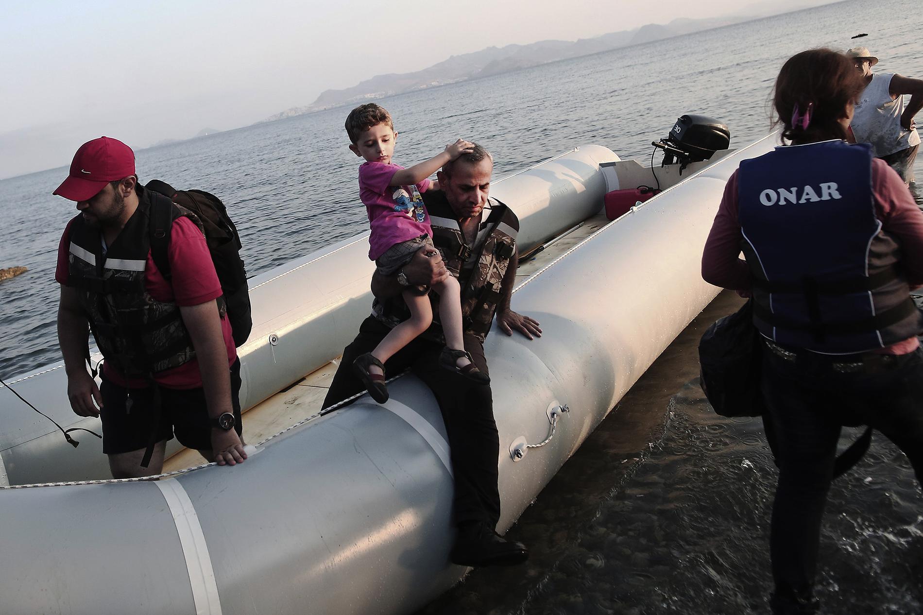 Syriska flyktingar hoppar i land på Grekiska ön Kos.