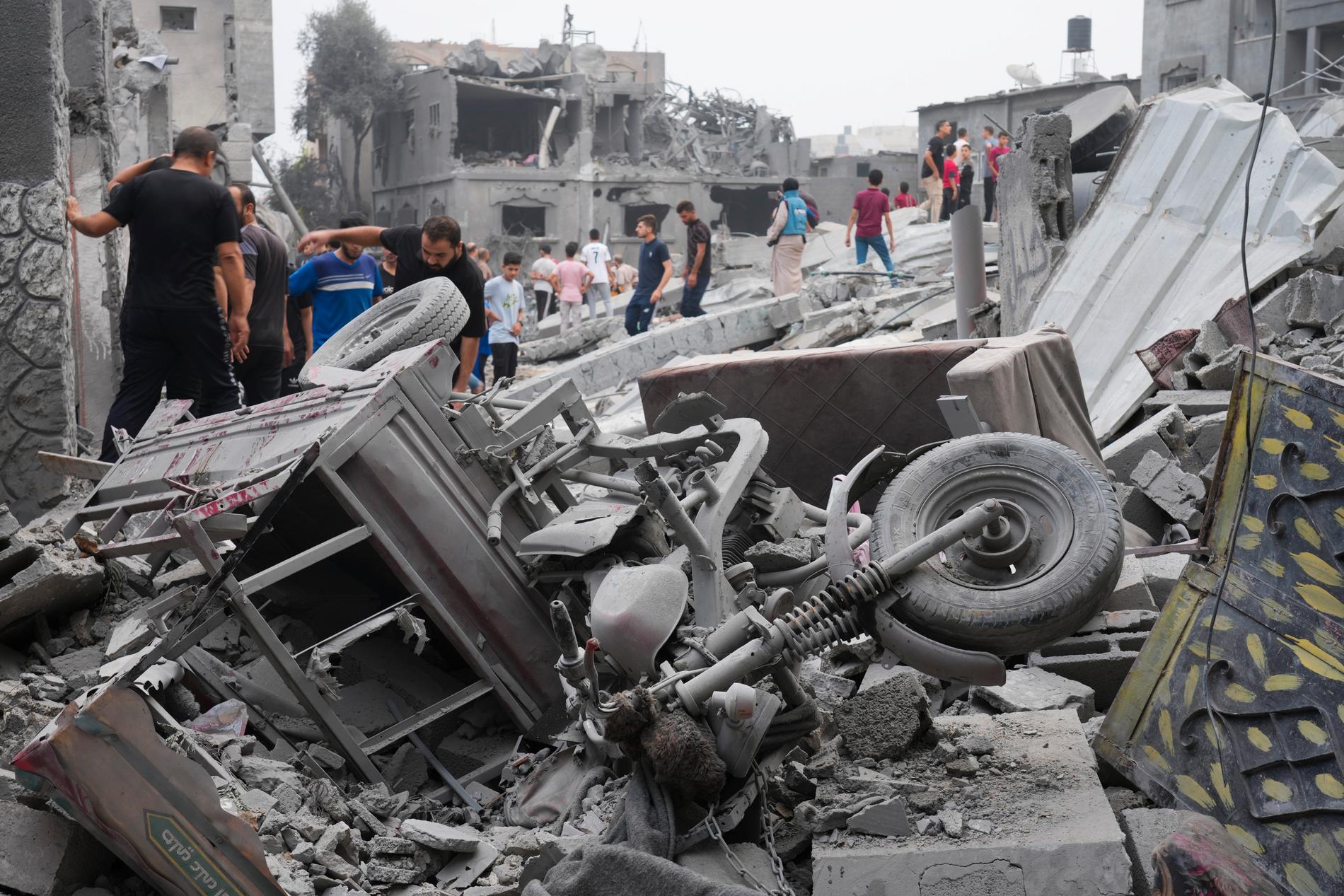 Boende letar igenom rasmassorna efter israeliska bombanfall mot flyktingförläggningen Nuseirat i Gaza.