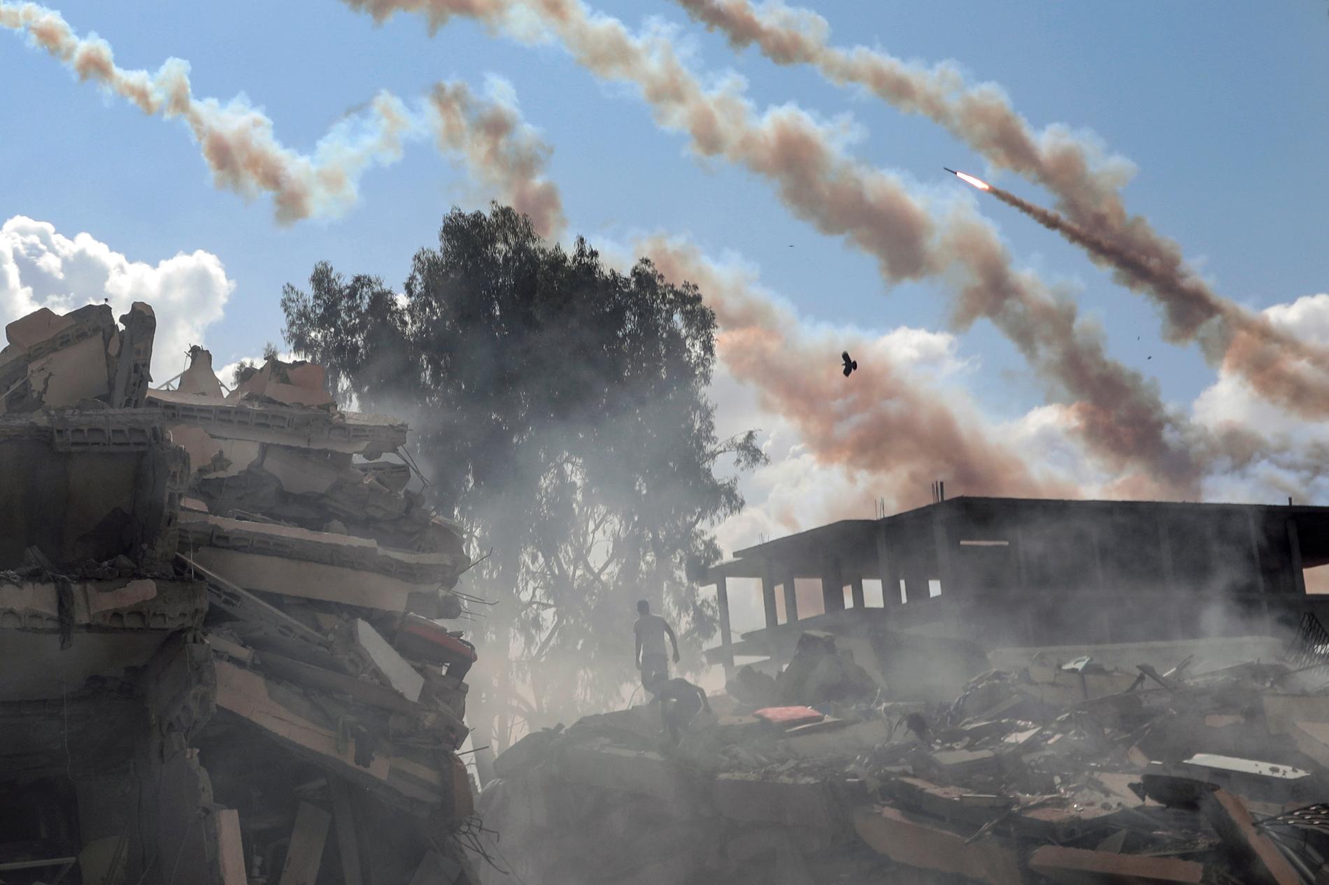 Raketer avfyras mot Israel från förstörda byggnader i Gaza, den 19 oktober, 2023.