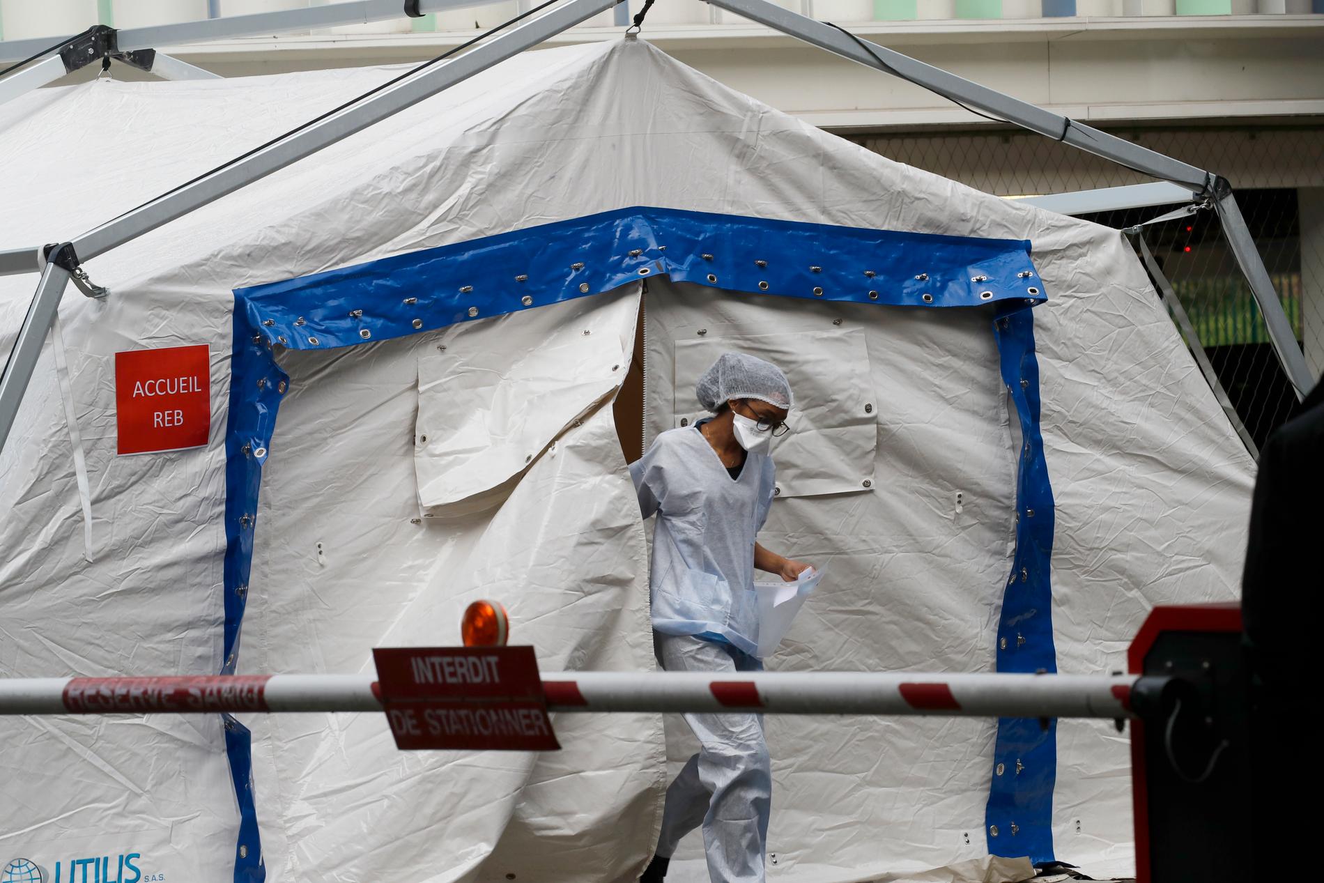 En läkare som behandlar coronasjuka patienter går ut ur ett provisoriskt tält som används som väntrum i Créteil, utanför Paris.