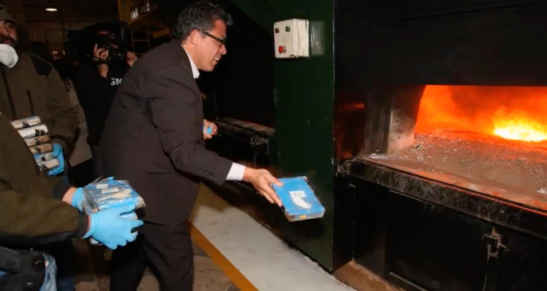 Ryska ambassadören Dmitry Feoktistov kastar några av förpackningarna med kokain in i ugnen.