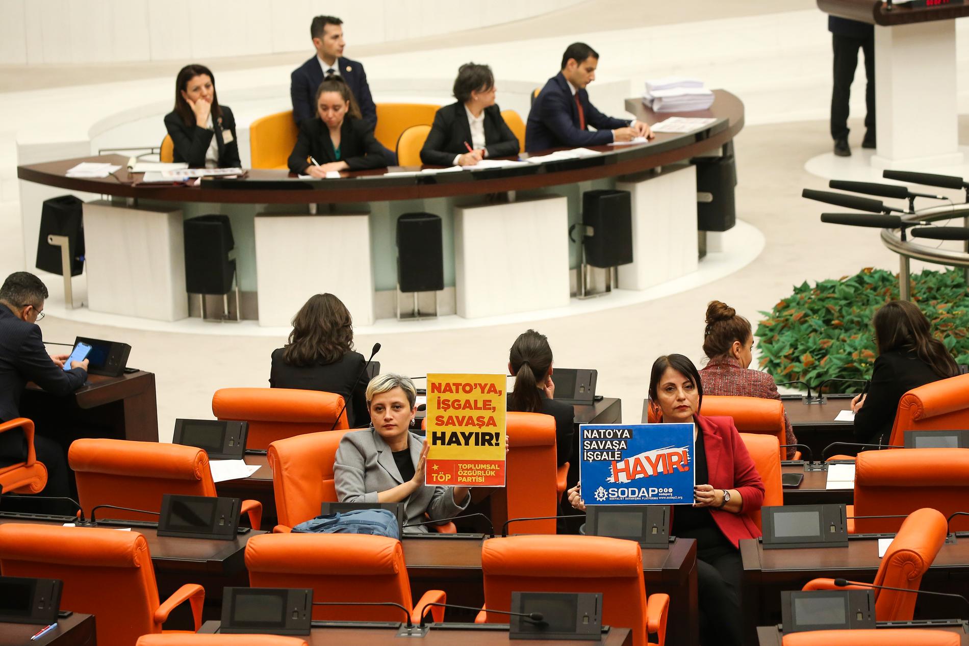 Under debatten i parlamentet hölls affischer upp med budskap som ”Ingen ockupation, inget krig för Nato!”