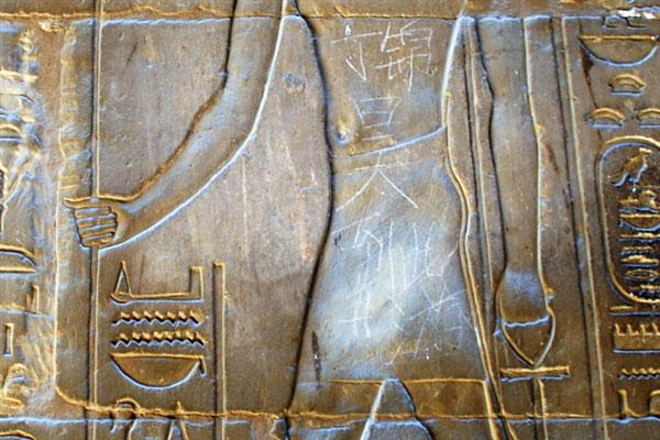En kinesisk pojke på semester i Luxor i Egypten orsakade ramaskri genom sin tagg "Ding Jinhao was here" på en 3500 år gammal staty.