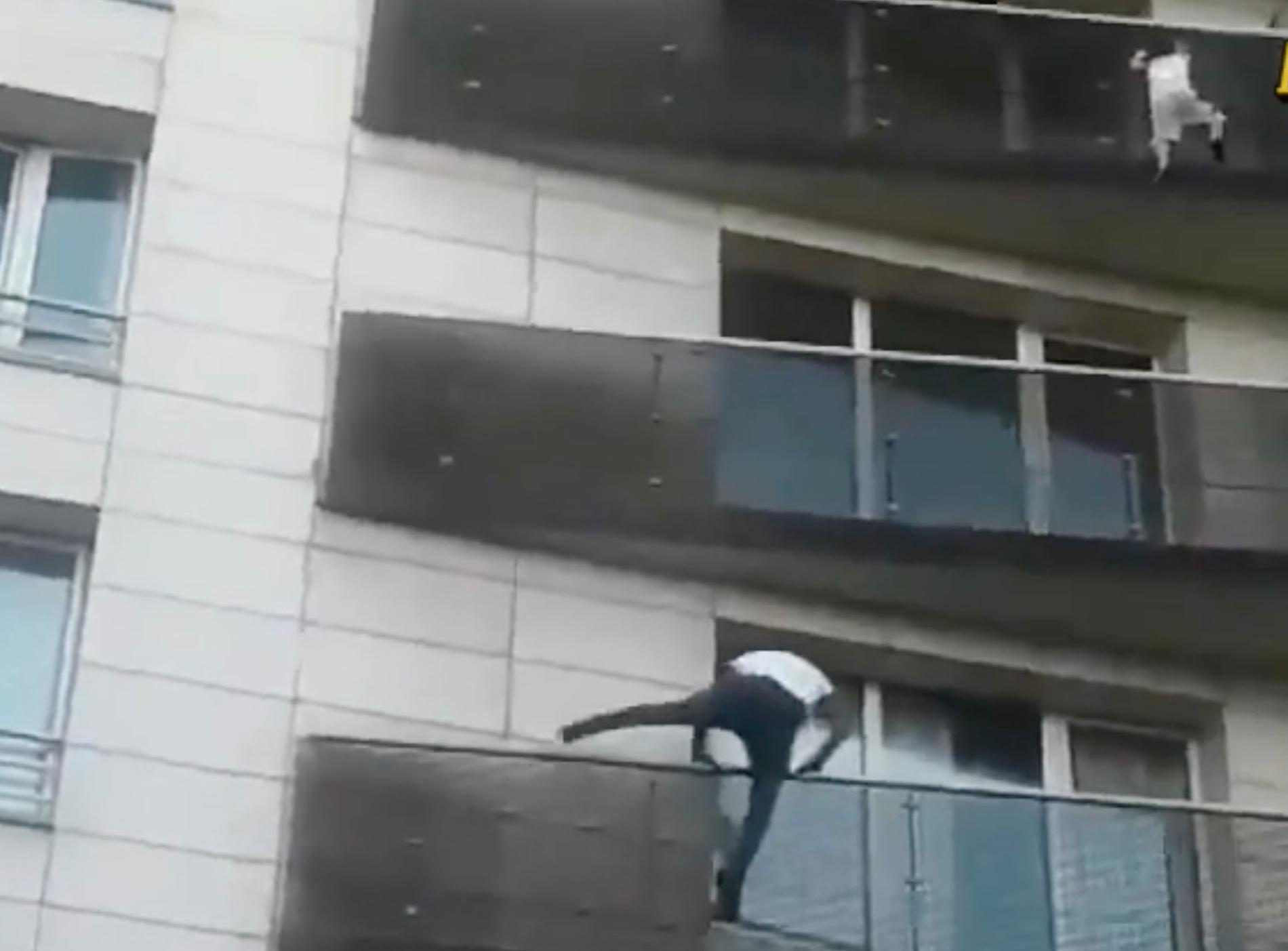 Mamoudou Gassama klättrar upp för att rädda barnet som hänger ut från balkongen.