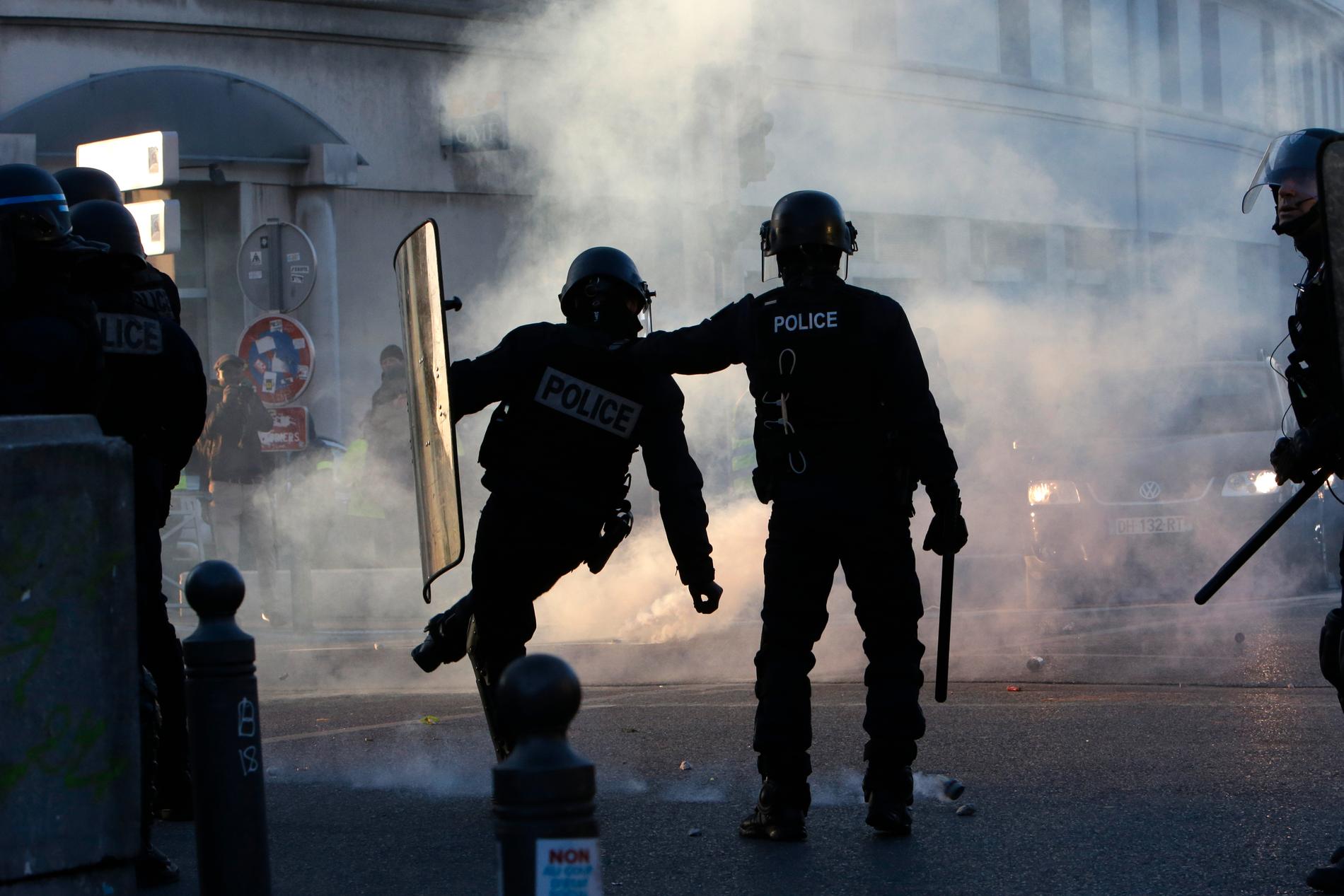 Kravallpolis i Marseille i södra Frankrike sparkar iväg en av polisens tårgasgranater. Bilden är från sammandrabbningar i samband med en av Gula västarnas manifestationer i januari i fjol.