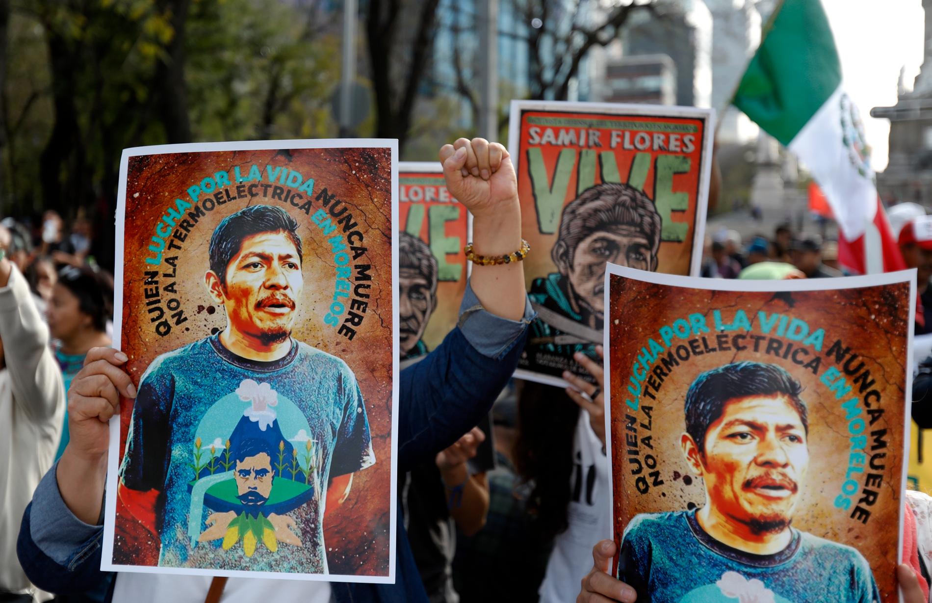 Människor håller upp bilder på en mördad aktivist, Samir Flores Soberanes, vid en manifestation i Mexikos huvudstad Mexico City.