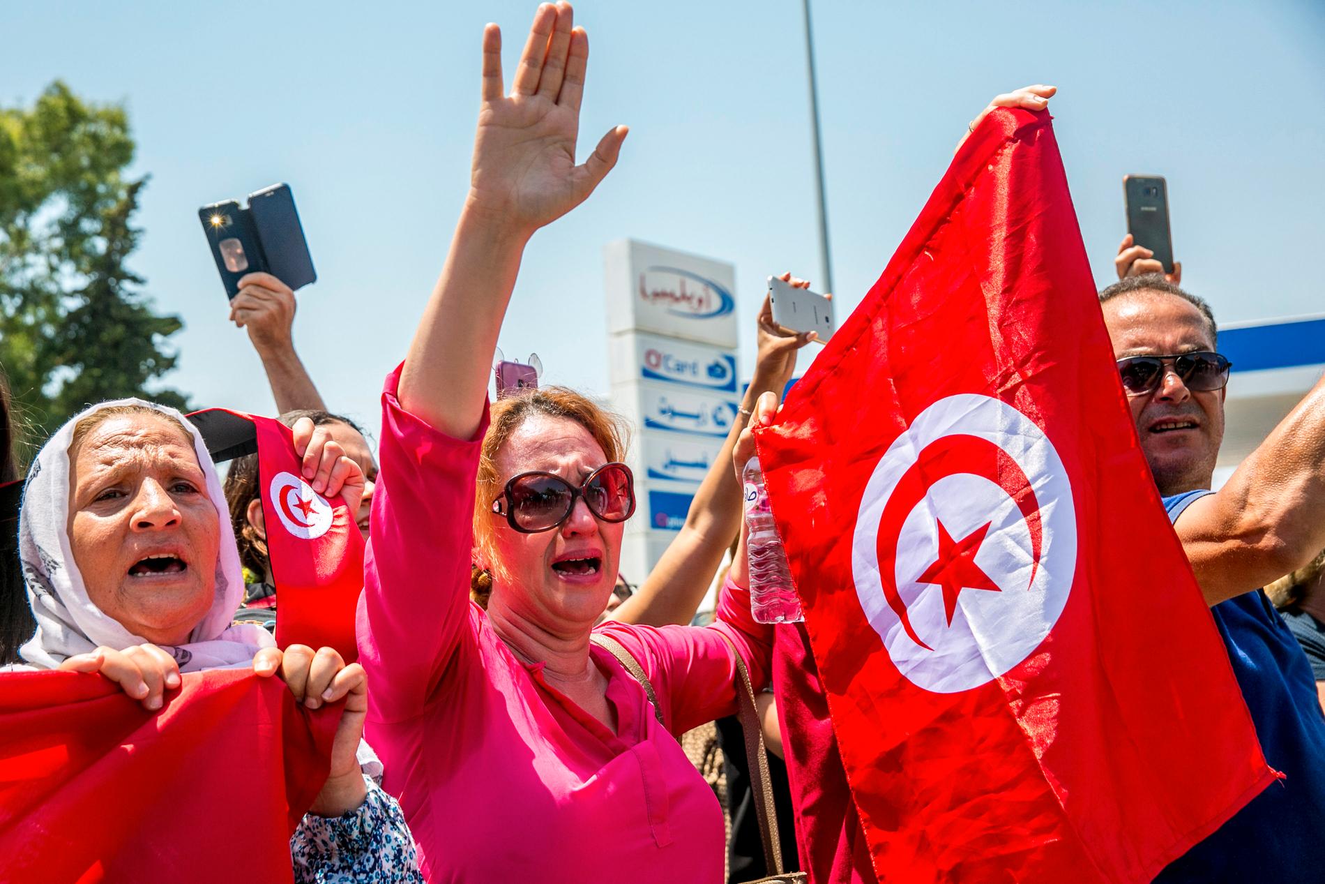 Människor sörjer när en konvoj med Essebsis kista anländer till presidentpalatset nära huvudstaden Tunis.