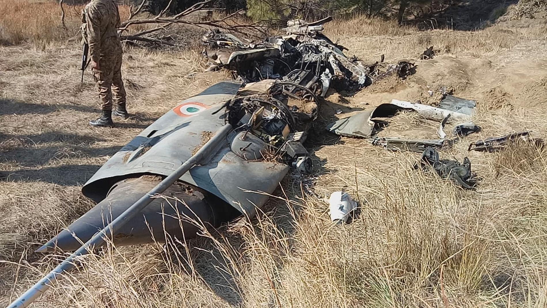 En pakistansk soldat bredvid det indiska flygplan som sköts ned av pakistansk militär. Den indiske pilot som tillfångatogs i samband med nedskjutningen har frigetts.