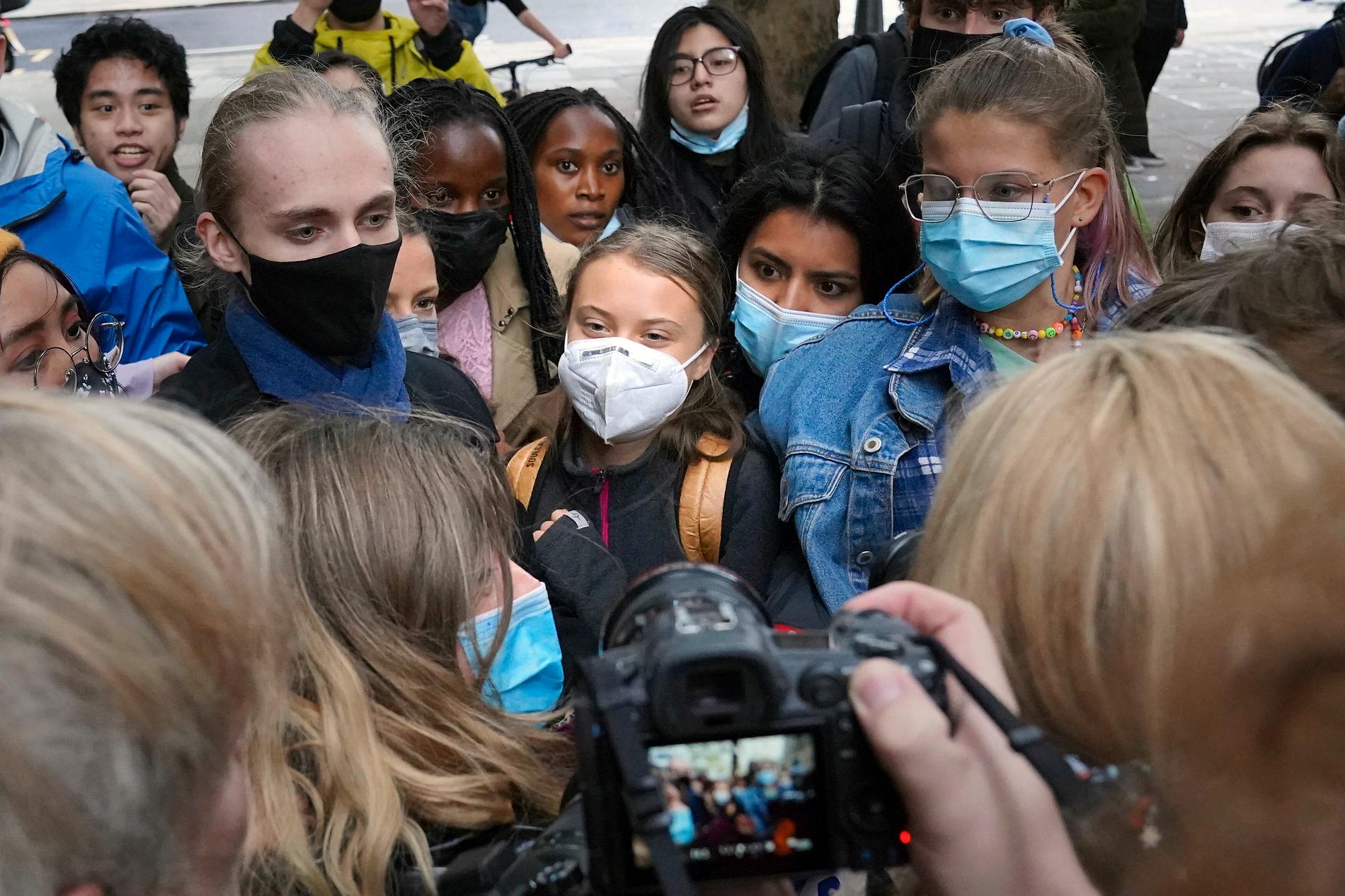 Greta Thunberg, mitten, under klimatprotester i London.