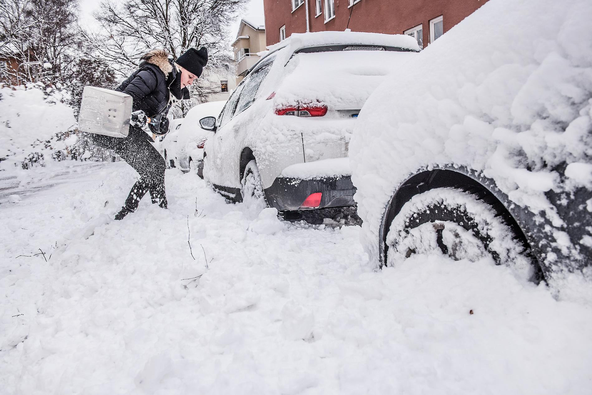 Jeanette i Bromma, Stockholm skottar ut sin bil efter nattens snöfall.