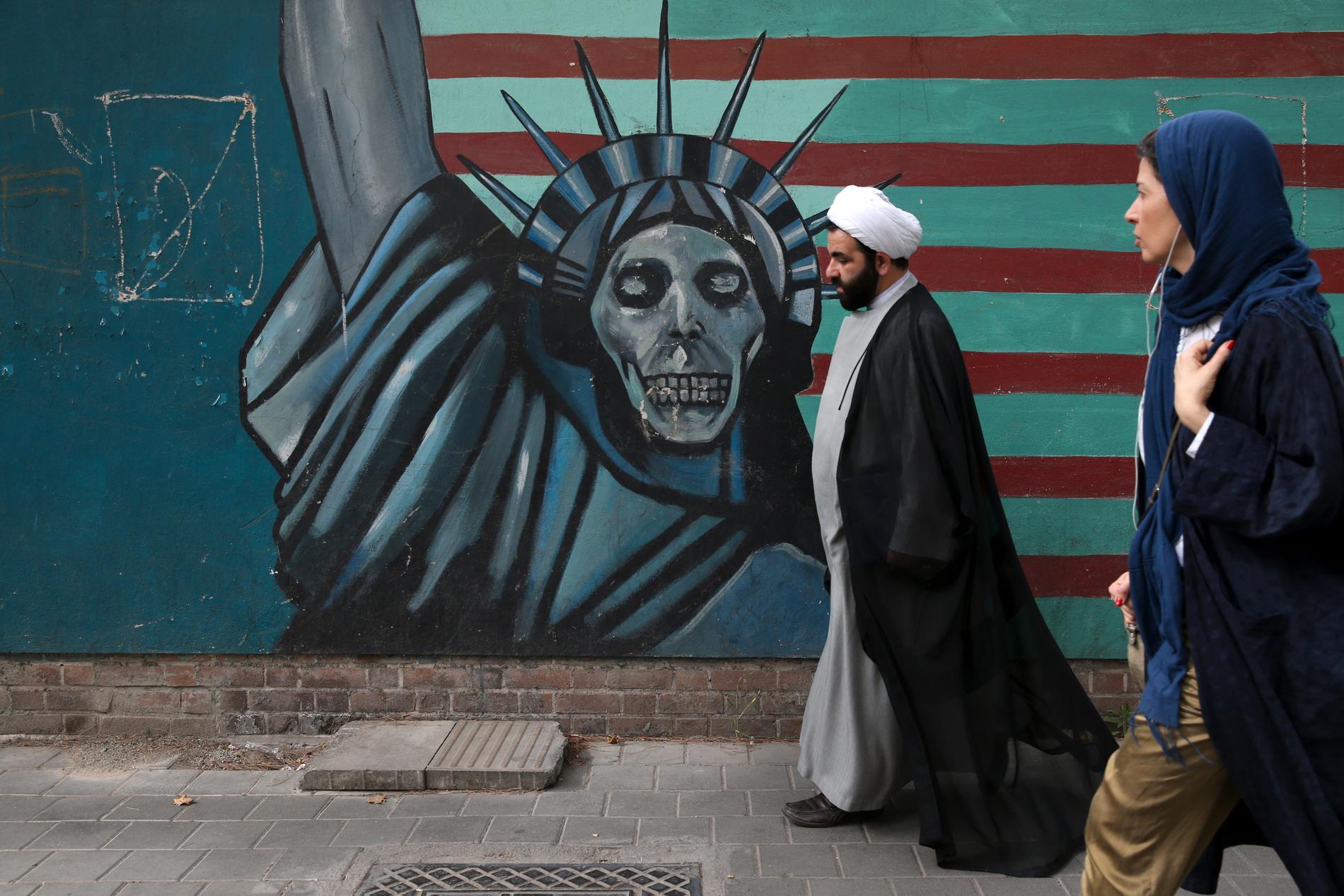 Frihetsgudinnan med skelettansikte står framför en flagga som utanför bild övergår i taggtråd som omger den iranska kartbilden. Arkivbild.