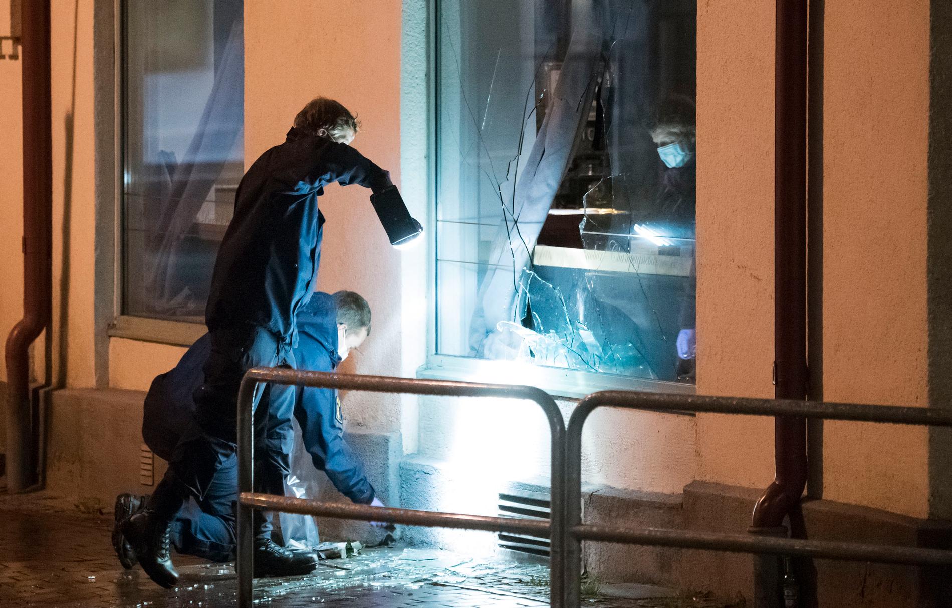 Polisens kriminaltekniker arbetar vid den krossade rutan till nattklubben i centrala Ängelholm efter nattens attentat.