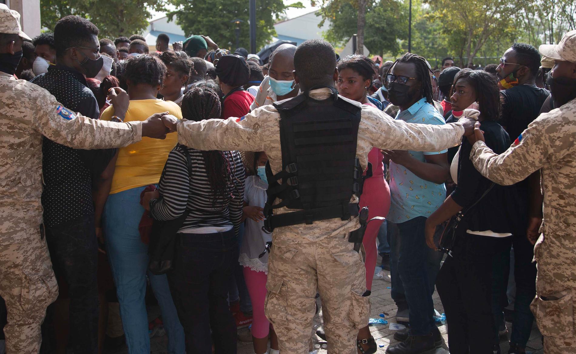 Haitisk polis försöker hindra folk att ta sig till USA:s ambassad i huvudstaden Port-au-Prince på fredagen.