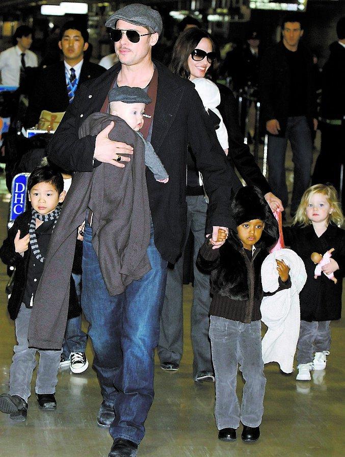 Brad Pitt bär på sonen Knox i en Babybjörn-sele. Här tillsammans med hela familjen.