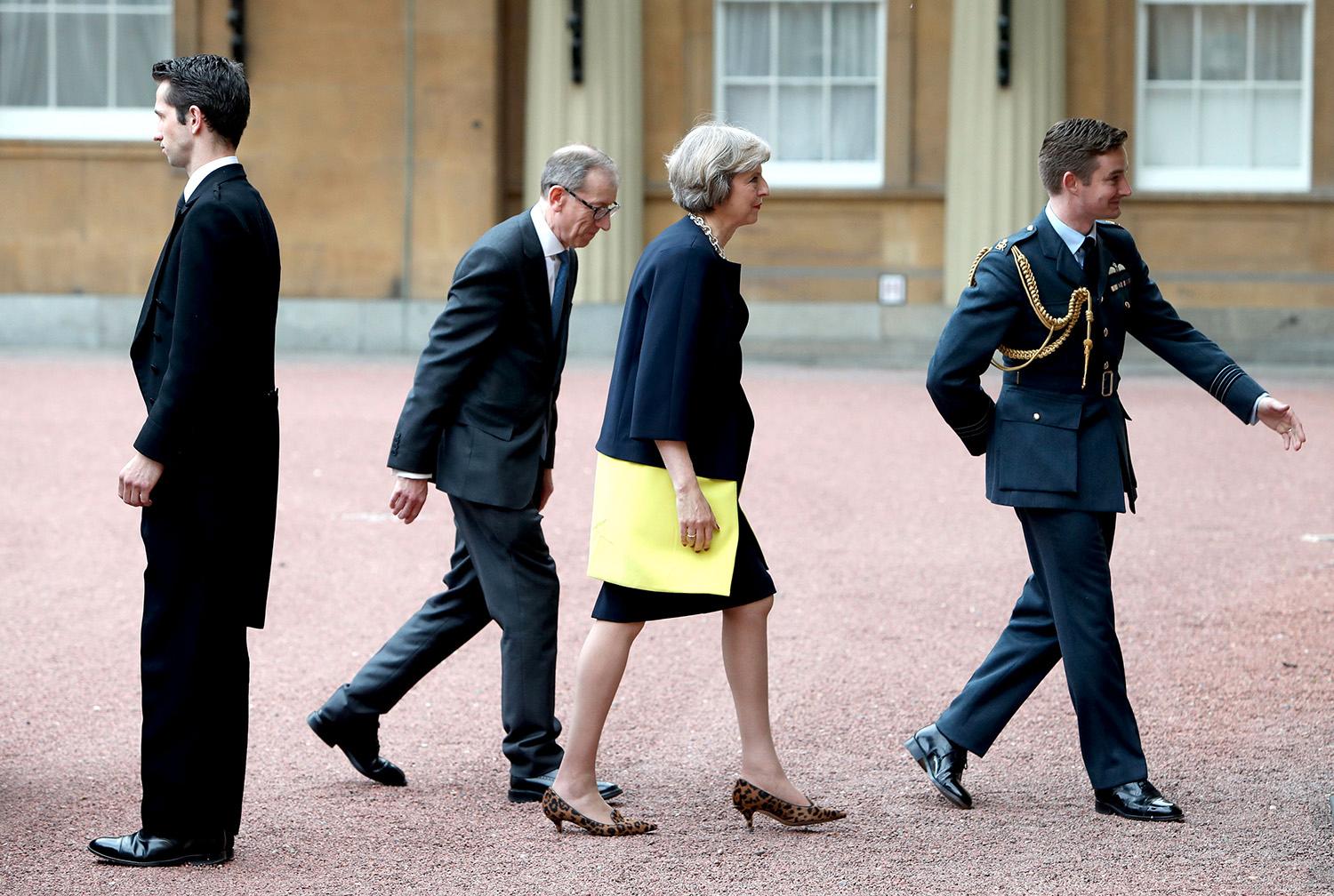 Theresa May med maken Philip May anländer till Buckingham Palace, London.
