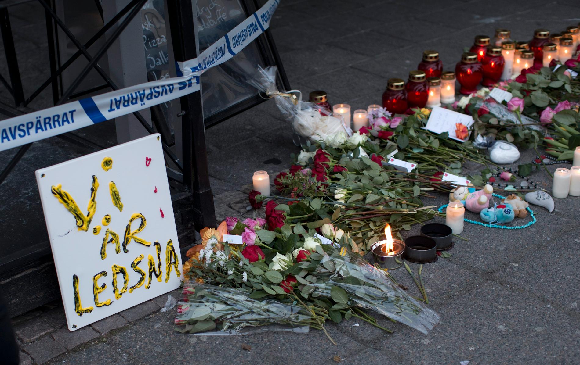 Blommor och ljus vid platsen för skottlossningen där två personer dödades och åtta skadades i mars 2015.