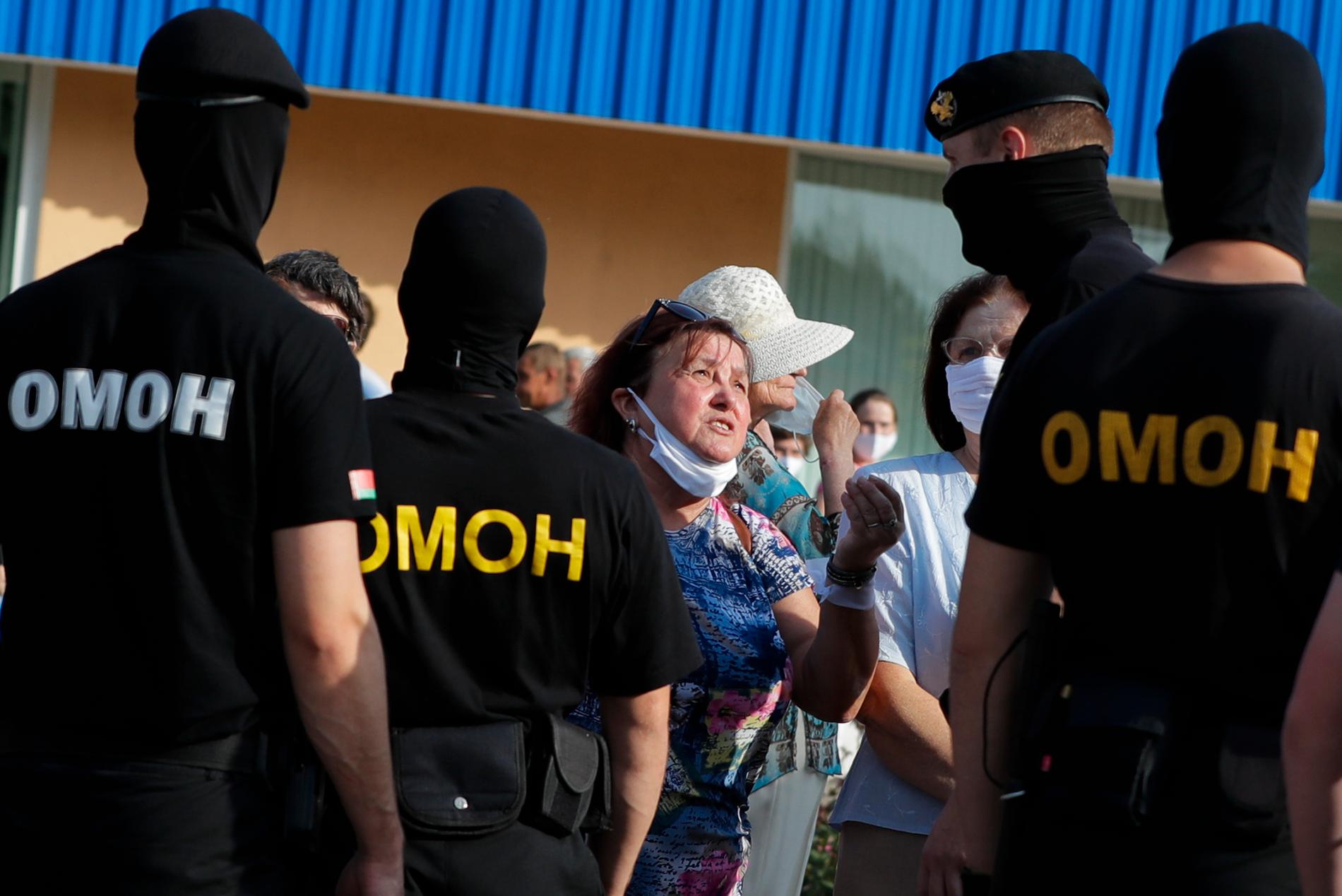 En kvinna argumenterar med polis som hindrar demonstranter som stöder oppositionskandidaten Svetlana Tichanovskaja.