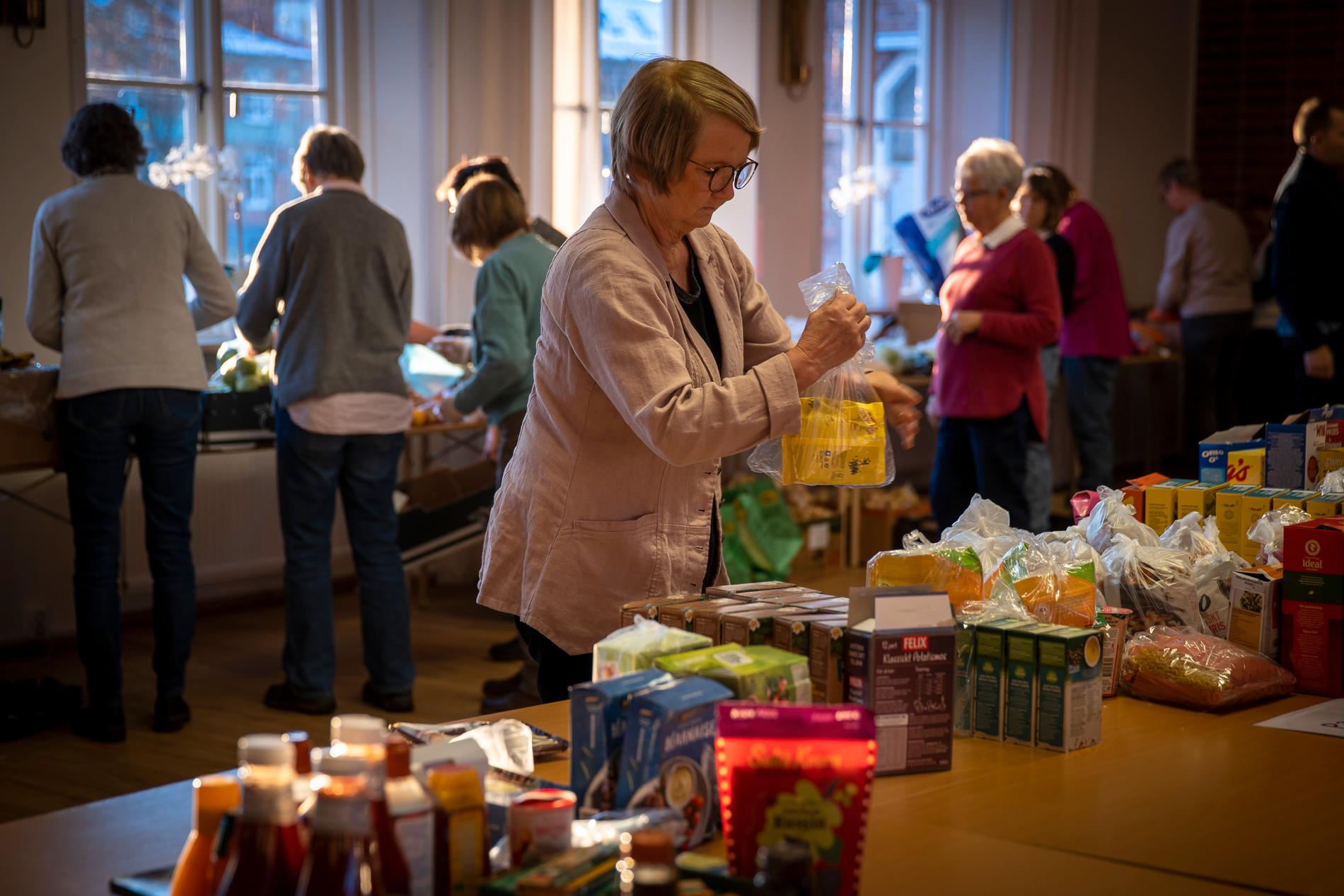 Frivilliga från olika kyrkor i Hässleholm hjälper till att packa matkassar, som delas ut en gång i månaden. Tidigare hade man utdelningen bara inför jul, men nu finns  behovet året runt. 