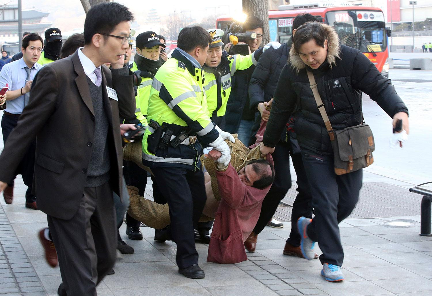 55-årige Kim Ki-Jong grips av polis efter rakbladsattacken mot USA:s ambassadör i Seoul.