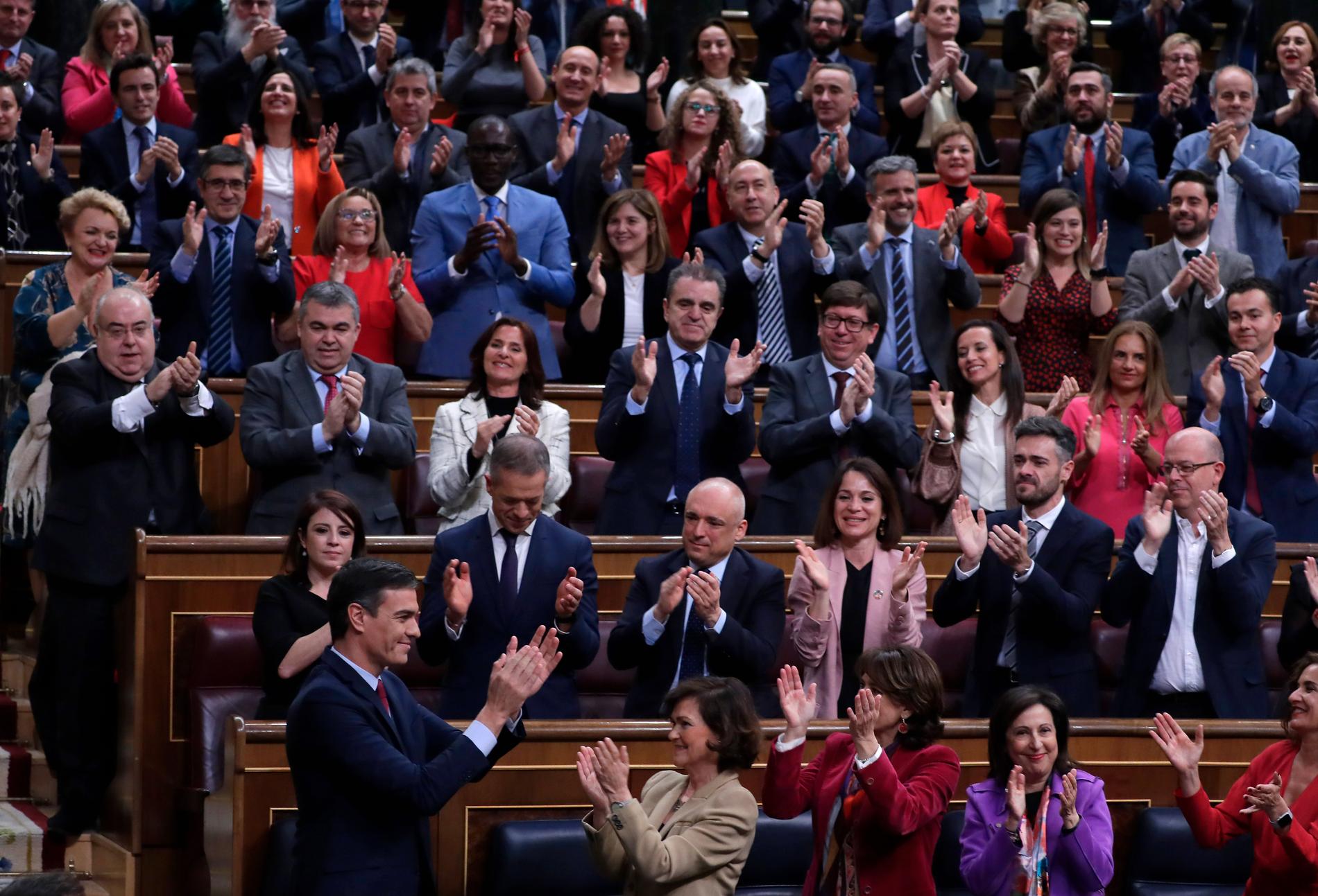 Pedro Sánchez applåderar ihop med sina socialdemokratiska partikamrater efter att med knapp marginal ha säkrat posten som premiärminister.