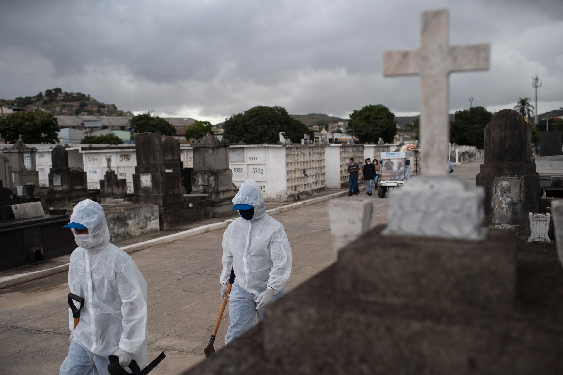 Begravningspersonalen jobbar i skyddsutrustning på kyrkogården i Rio de Janeiro. 