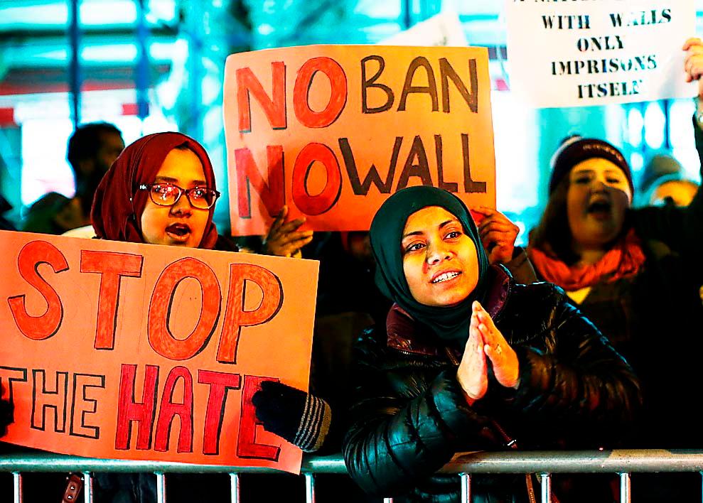 Demonstranter protesterar i New York mot Donald Trumps inresestopp.  ”Kampen mot Trump får inte bli en sträcvan tillbaka till det gamla, skriver Åsa Linderborg.