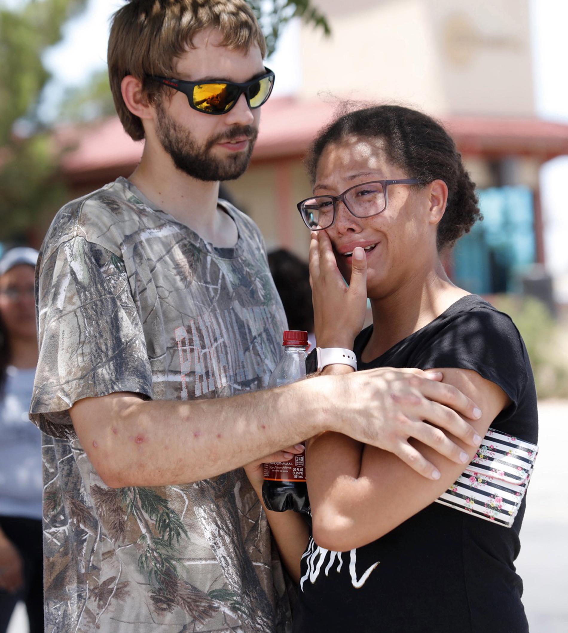 Besökare tröstar varandra efter lördagens massaker vid ett shoppingcenter i El Paso, Texas.