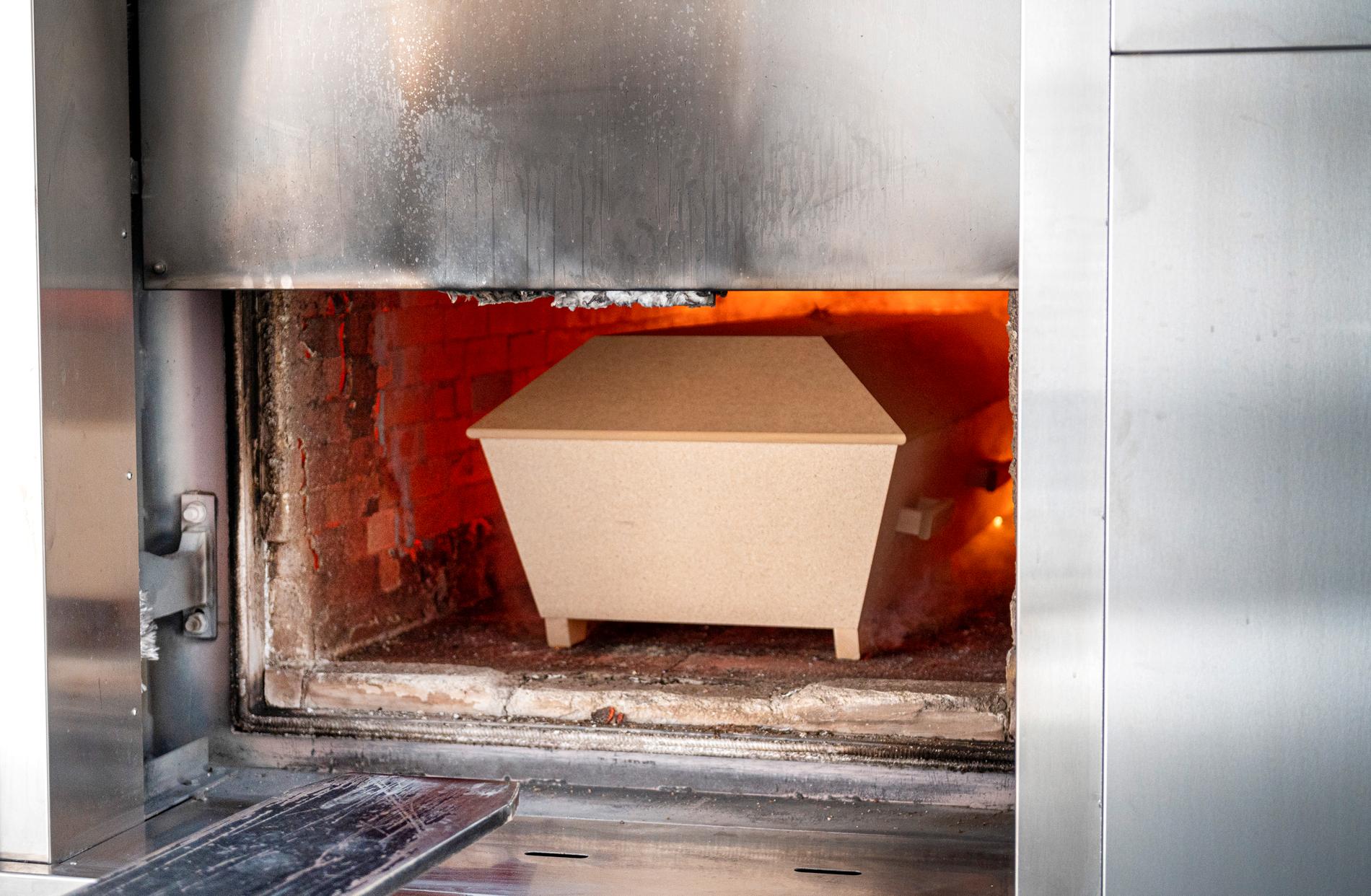 En kista förs in och bränns i ugnen, vid krematoriet på Skogskyrkogården i Stockholm.