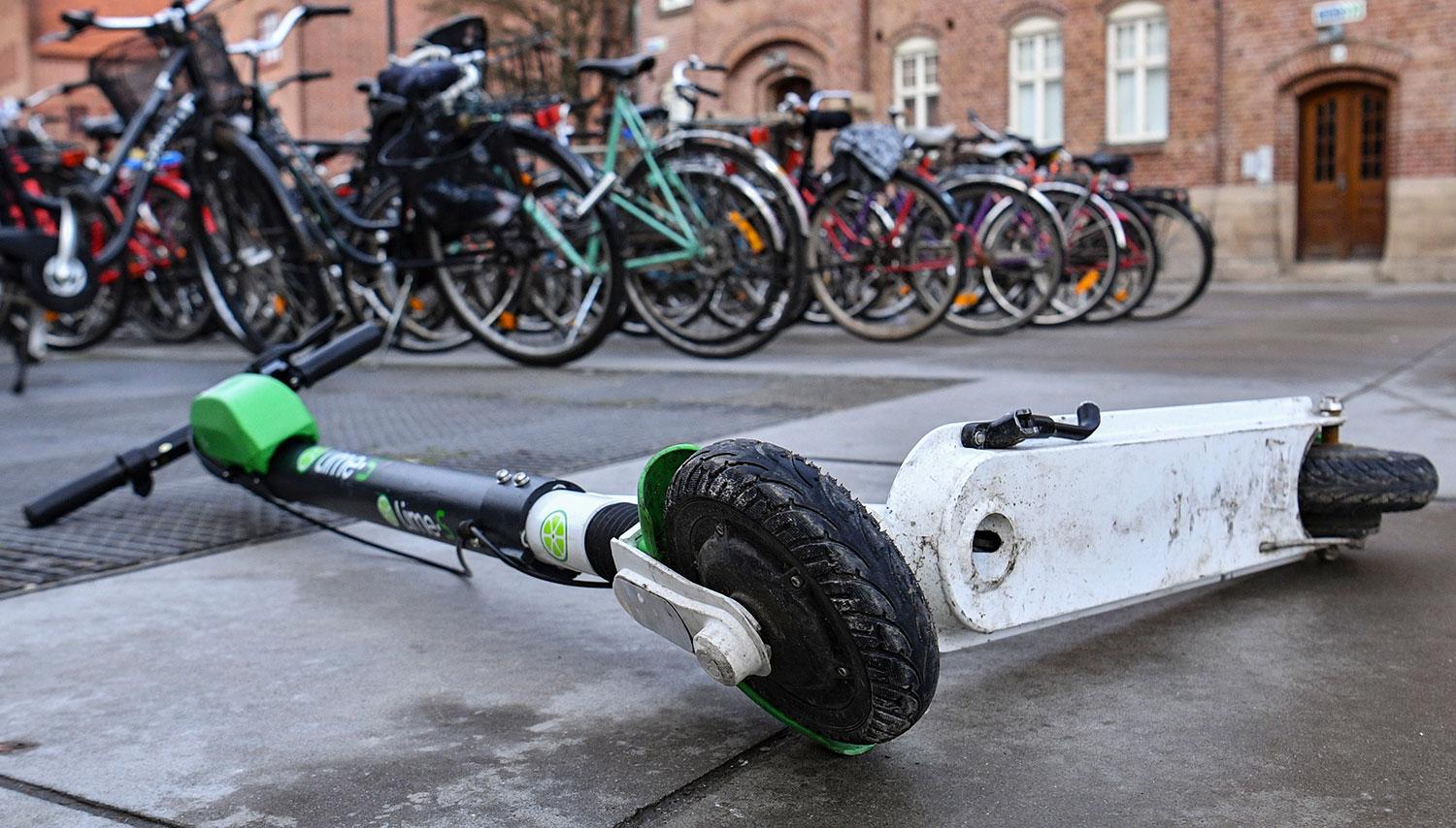 Elscooter liggande vid ett cykelställ utanför Triangeln i Malmö.