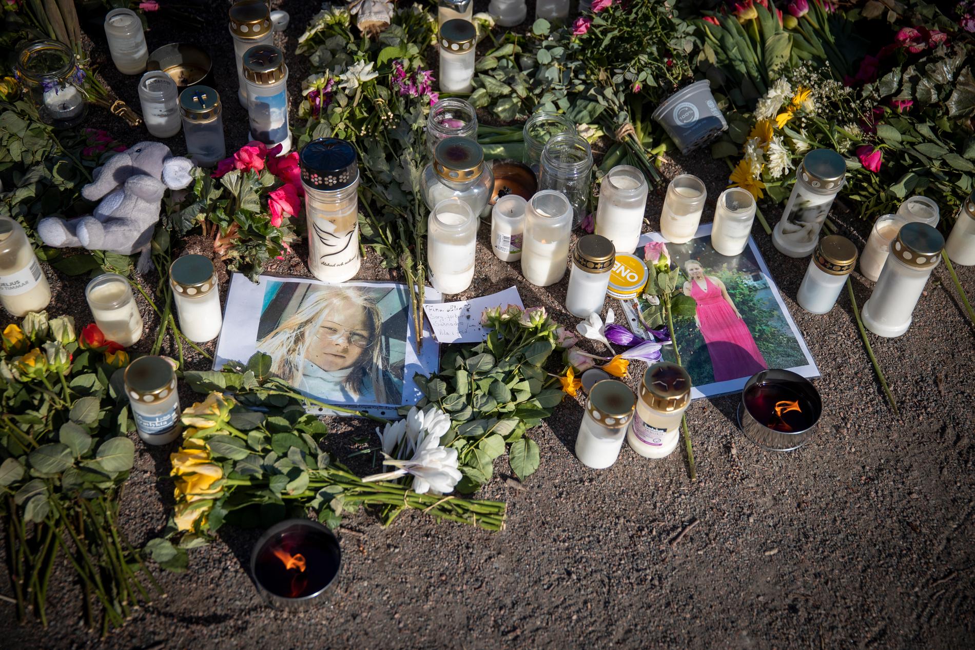 Blommor, ljus och fotografier vid en minnesplats för Elin.