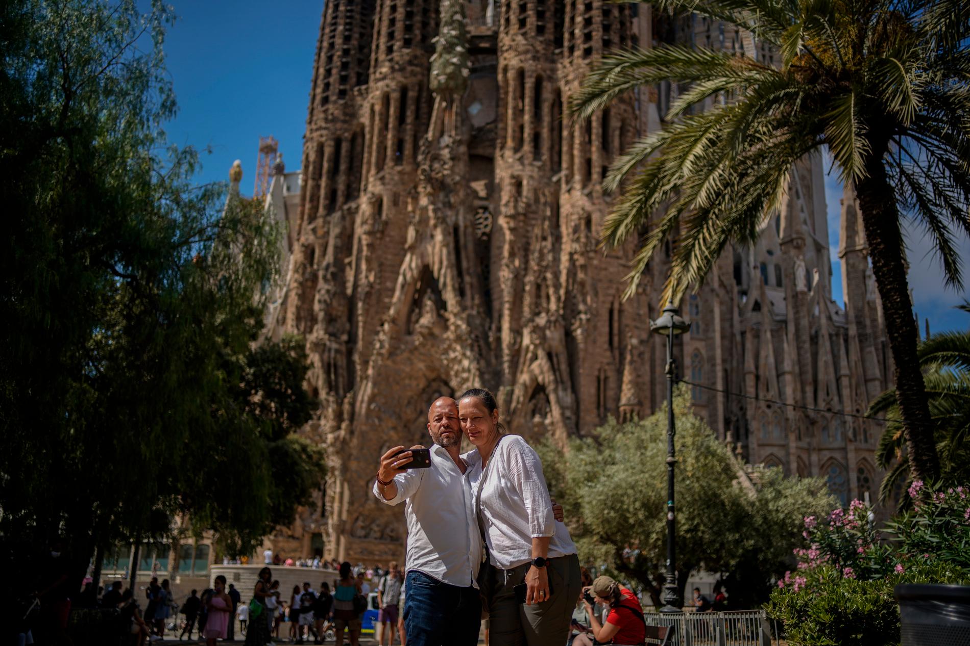 Två personer tar en selfie med La Sagrada Familia i bakgrunden.