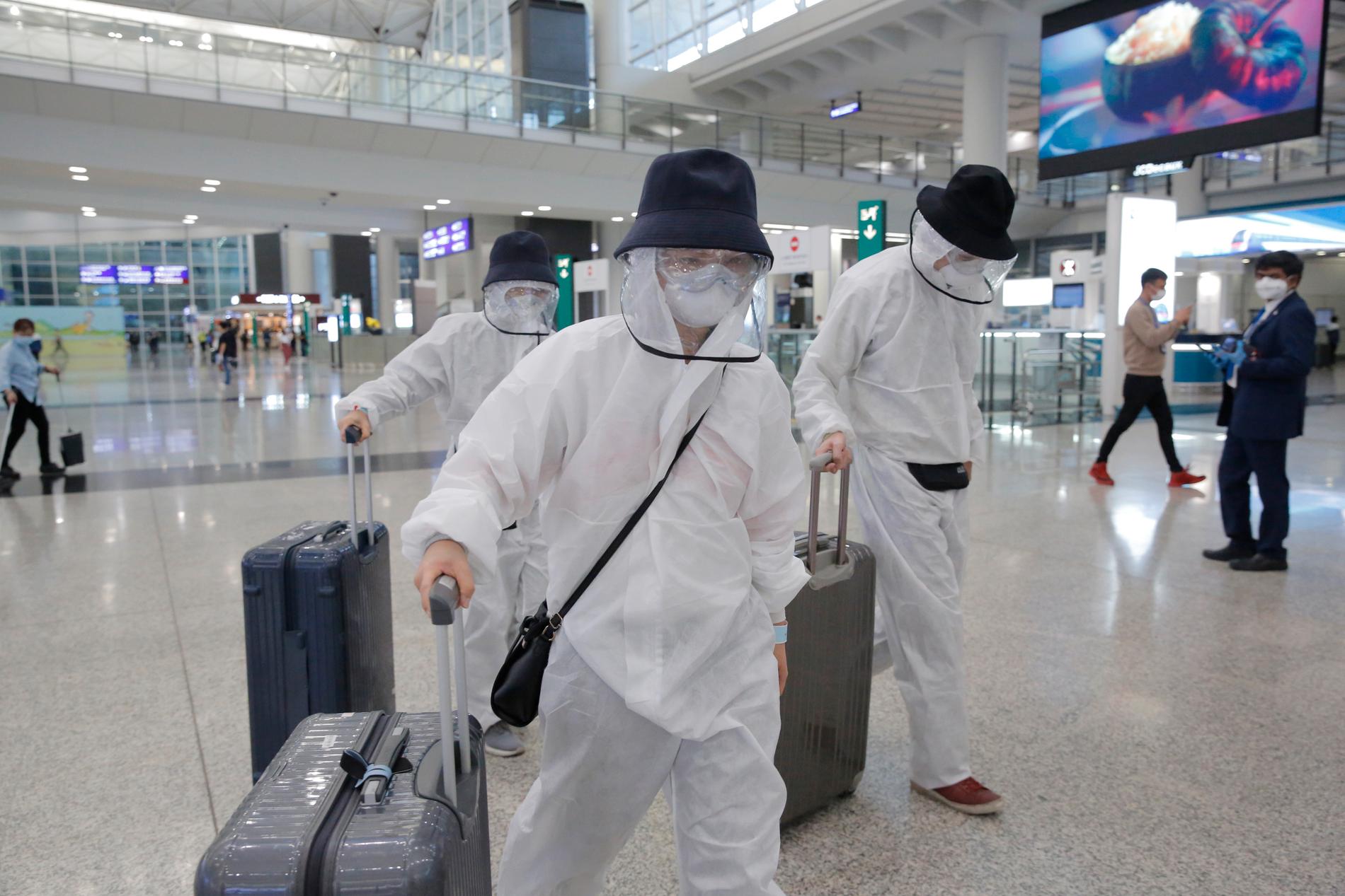 HONGKONG, KINA Resenärer på flygplatsen i Hong Kong bär skyddskläder från topp till tå på måndagen.