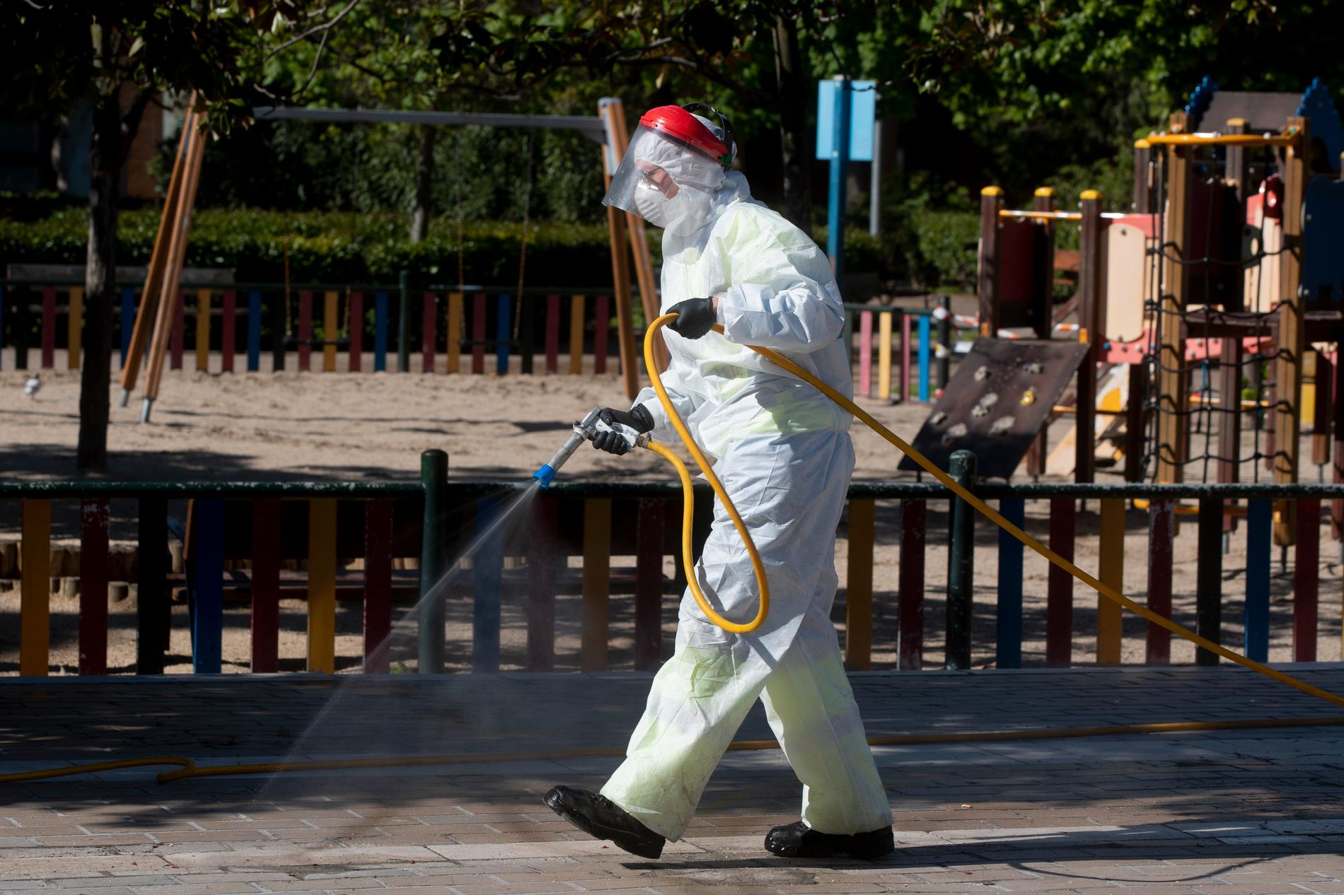 En renhållningsarbetare desinficerar området kring en lekplats i Spaniens huvudstad Madrid. Bilden är från den 20 april.