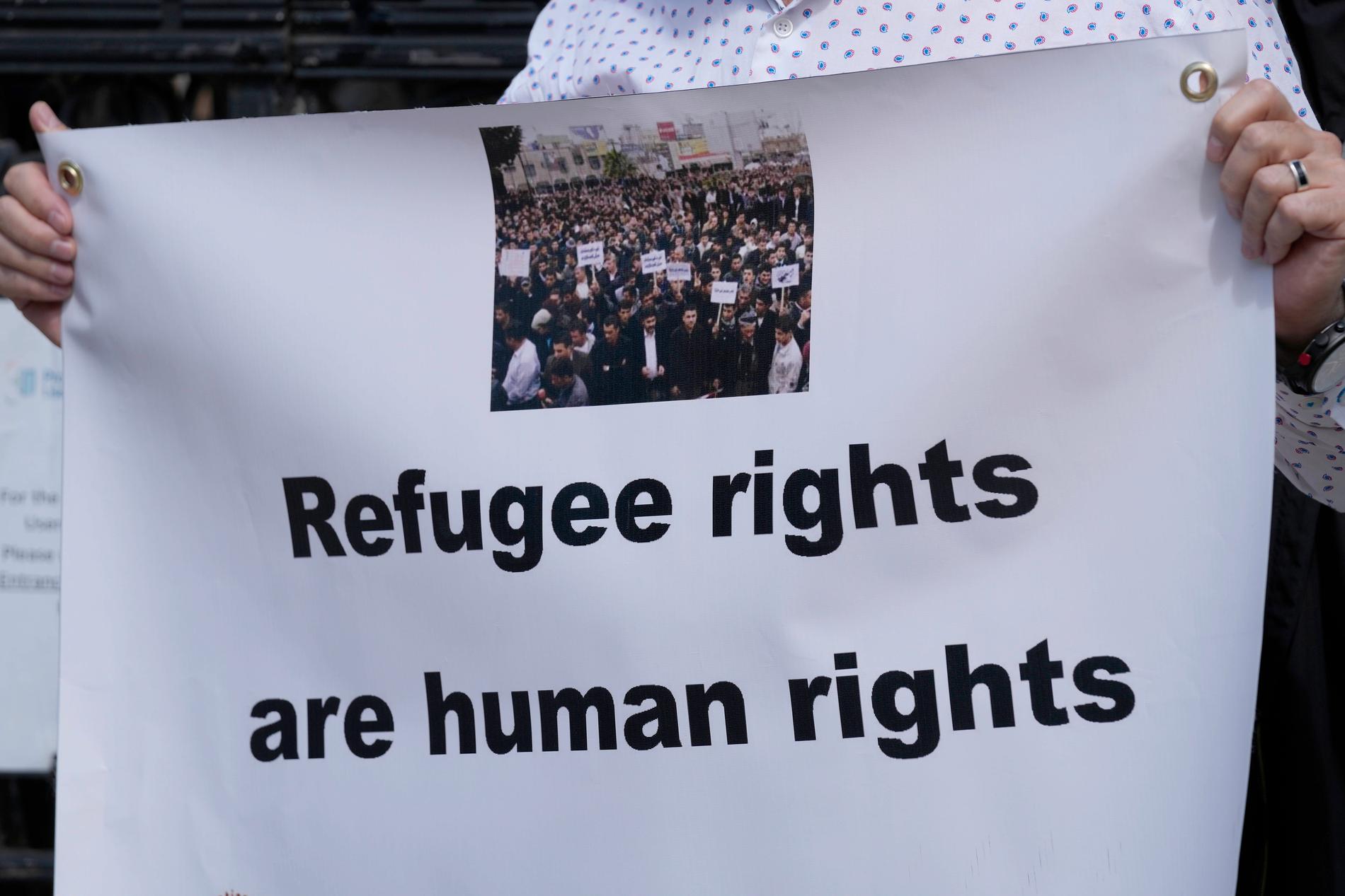 Demonstrant med plakattexten – Flyktingars rättigheter är mänskliga rättigheter – utanför en domstol i London som i fredags genom en dom godkände det kontroversiella beslutet att skicka brittiska migranter till Rwanda.