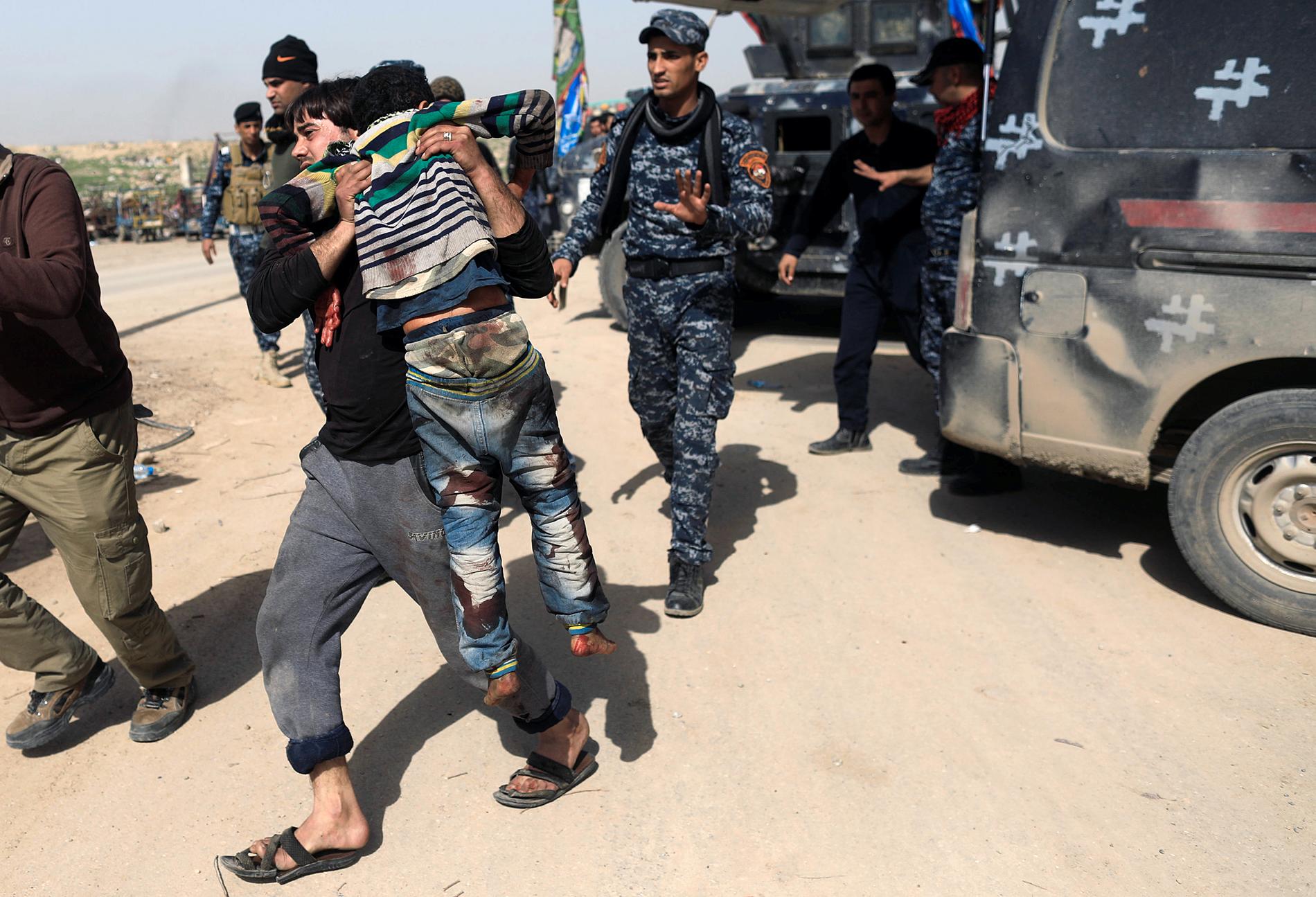 En man tar hand om en skadad anhörig i västra Mosul. 