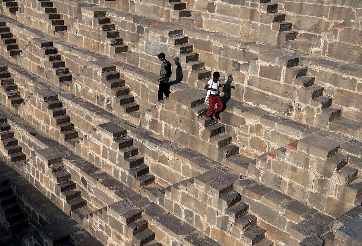 Abhaneri, Indien: Två unga indier springer ner för den 1200 år gamla jättetrappan Chand Baori. De cirka 3500 stegen får bara beträdas en gång om året i samband med en högtid.