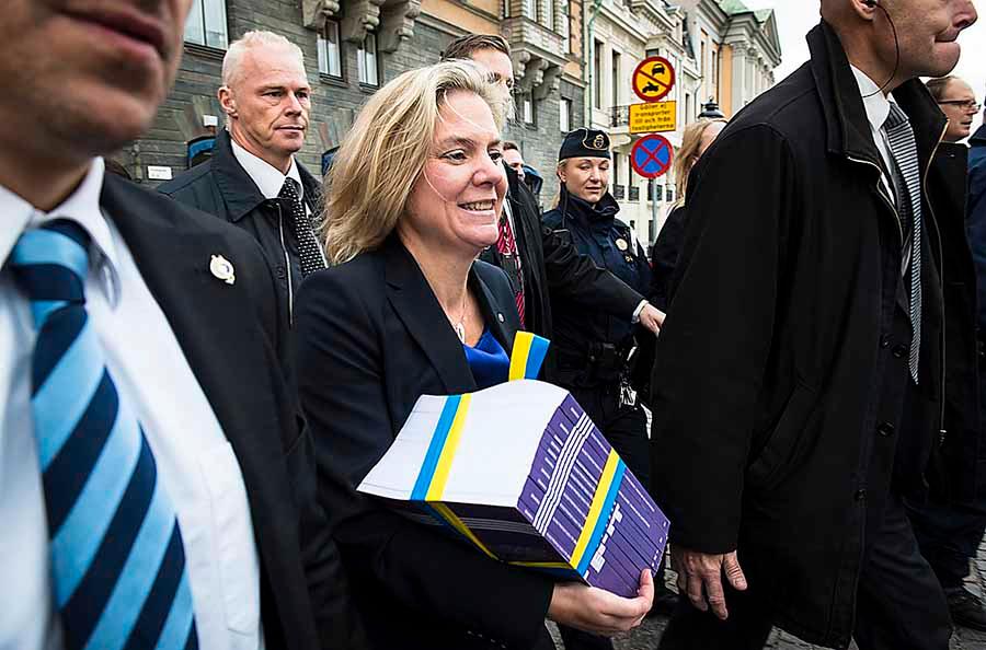 Magdalena Andersson bär runt på S budgetförslag. Nu har hon även fått överta stafettpinnen – att få fart på Sverige ekonomi – från Stefan Ingves.
