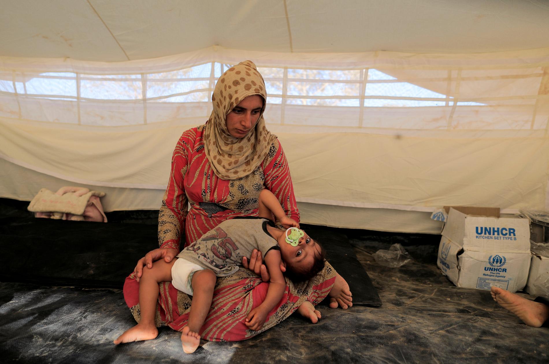 En kvinna med sitt barn i ett flyktingläger i Tawayneh