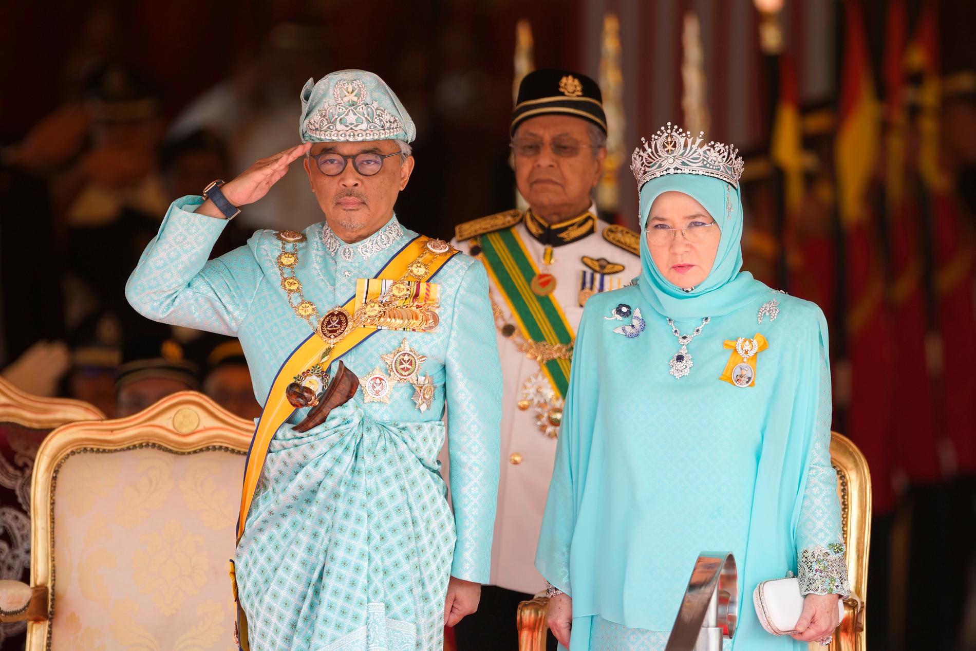 Malaysias nye kung Abdullah gör honnör under ceremonin i Kuala Lumpur. Vid hans sida, i matchande kläder, syns drottning Tunku Azizah Aminah Maimunah.