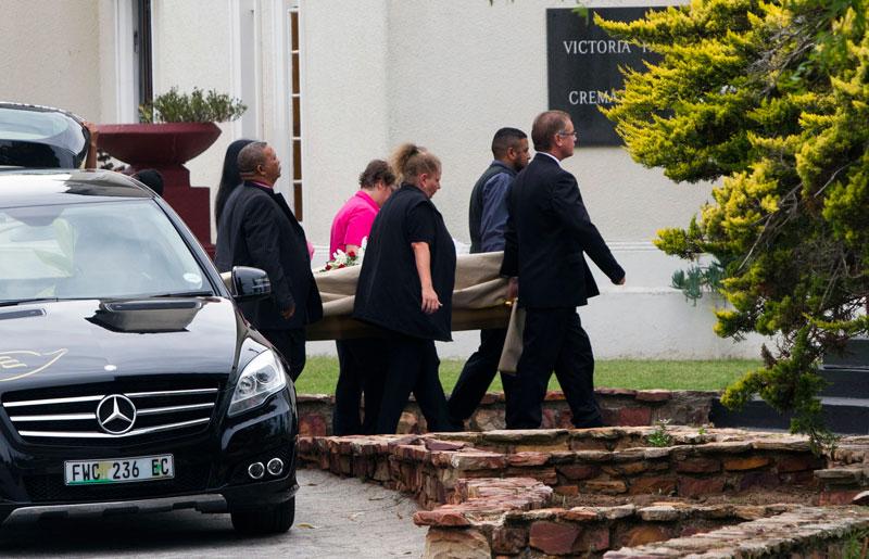 Samtidigt som häktesförhandlingarna begravdes Reeva Steenkamp. Här bärs kistan in till krematoriet.
