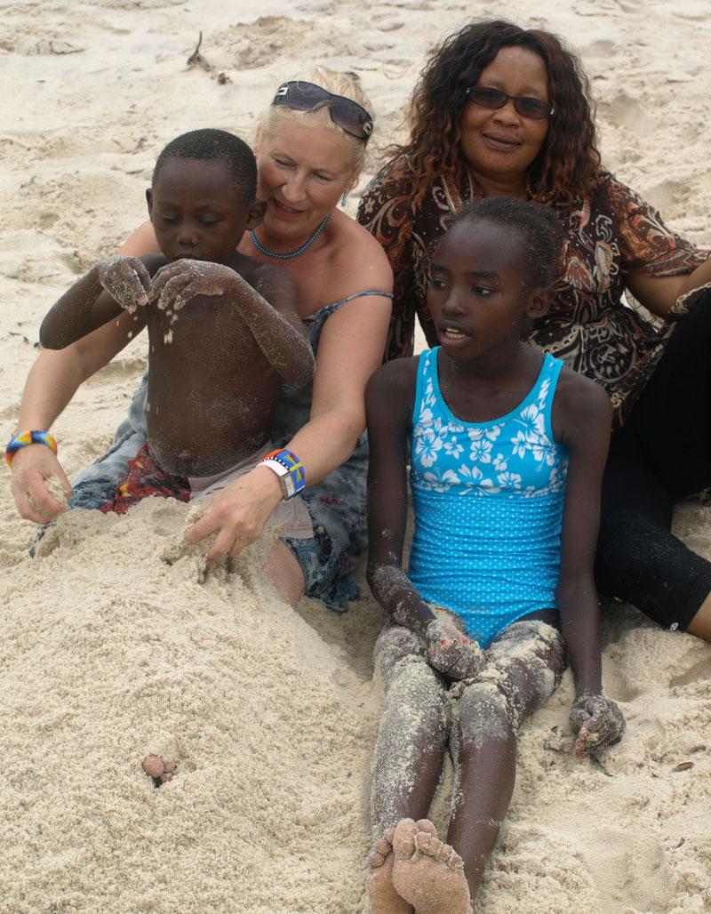 Margaretha på stranden med två av barnen från barnhemmet och föreståndaren Caroline Omburo.