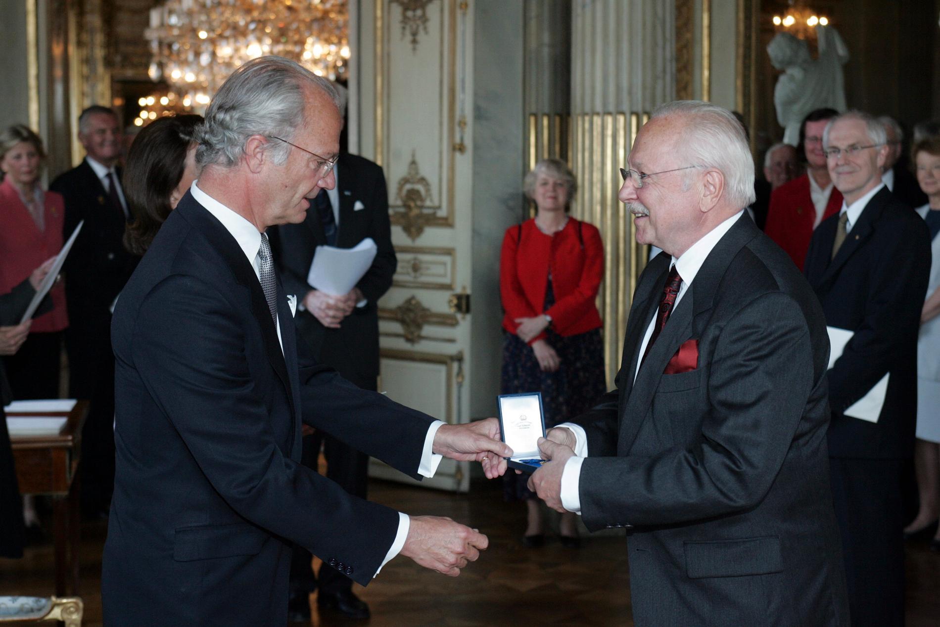 En glad Ingvar Hirdwall tar emot medaljen Litteris Et Artibus av kungen 2005.