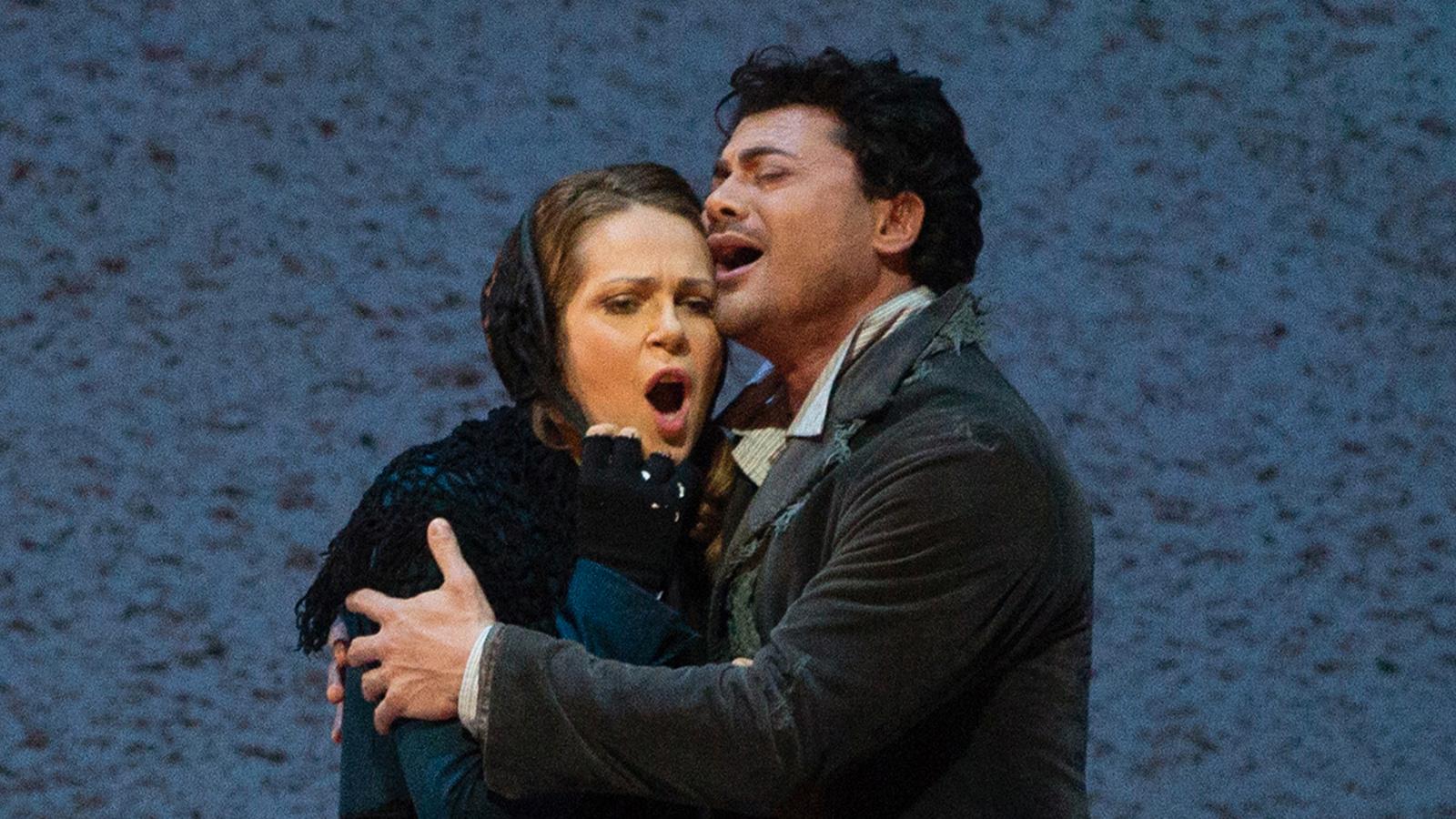 Vittorio Grigolo och Kristine Opolais i Puccinis opera "La Boheme”. Arkivbild.